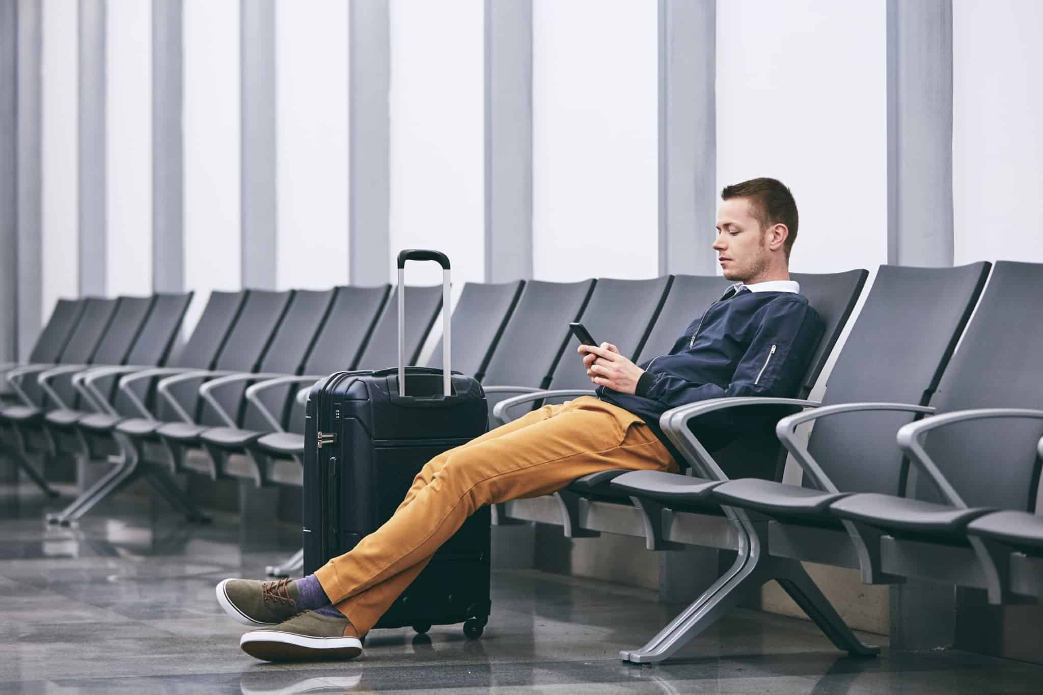 homem sentado na sala de espera de um aeroporto