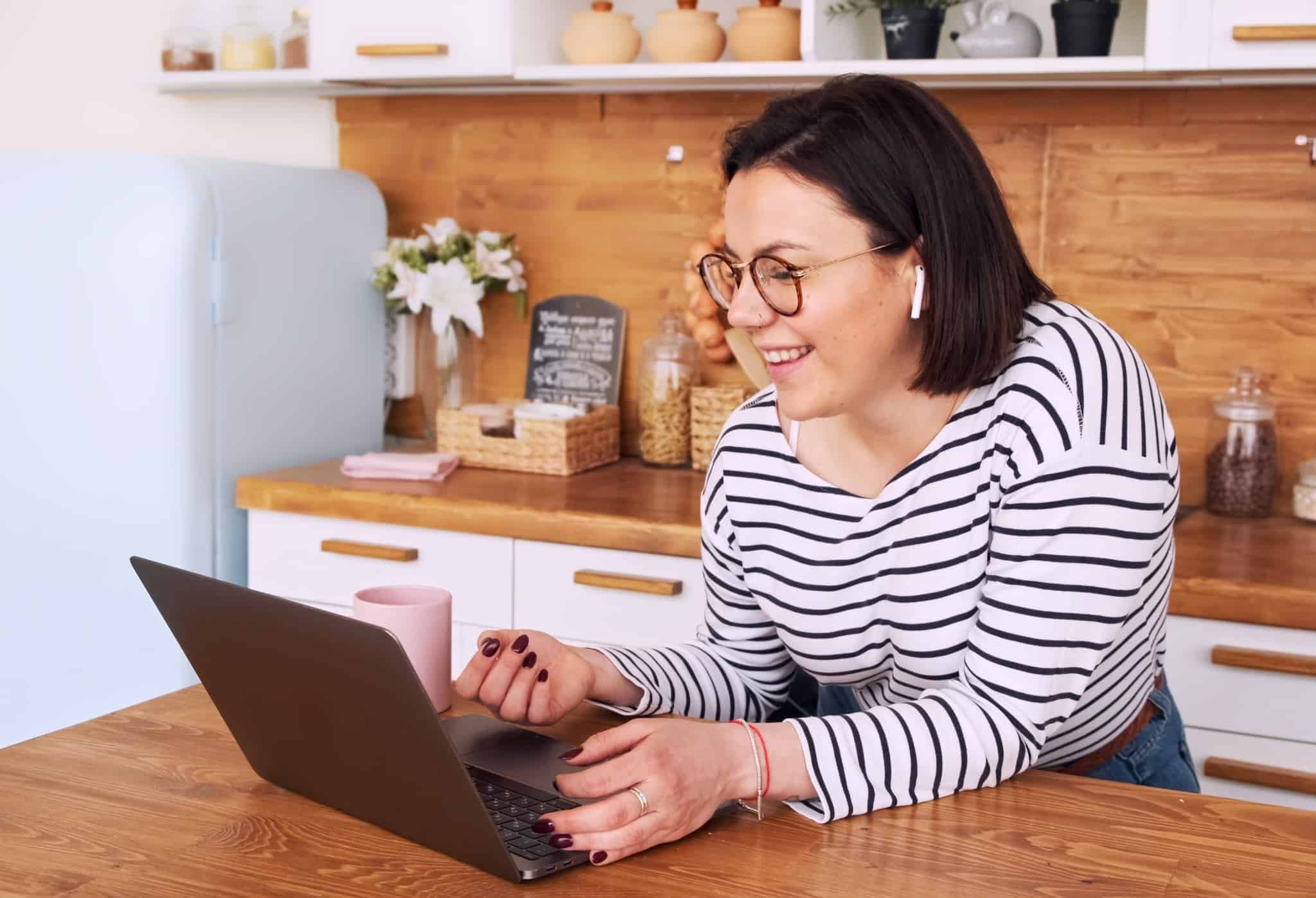 rapariga a fazer um curso online na mesa da cozinha