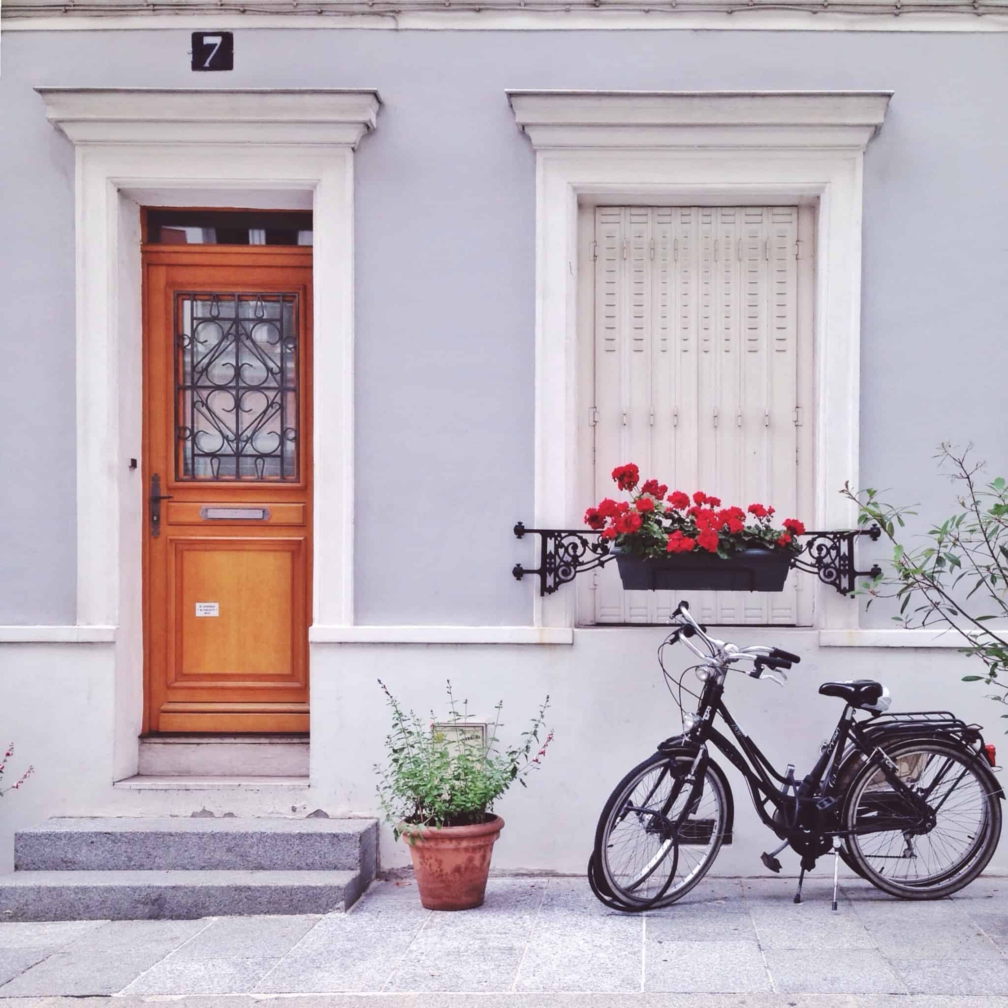 porta de madeira com o numero sete e uma bicicleta ao lado, que mostram uma zona tradicional e segura, onde teria facilidade de vender a sua casa