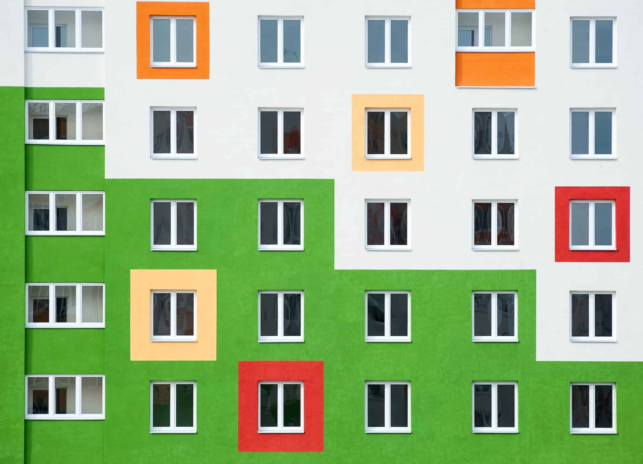 prédio metade verde e metade branco com janelas