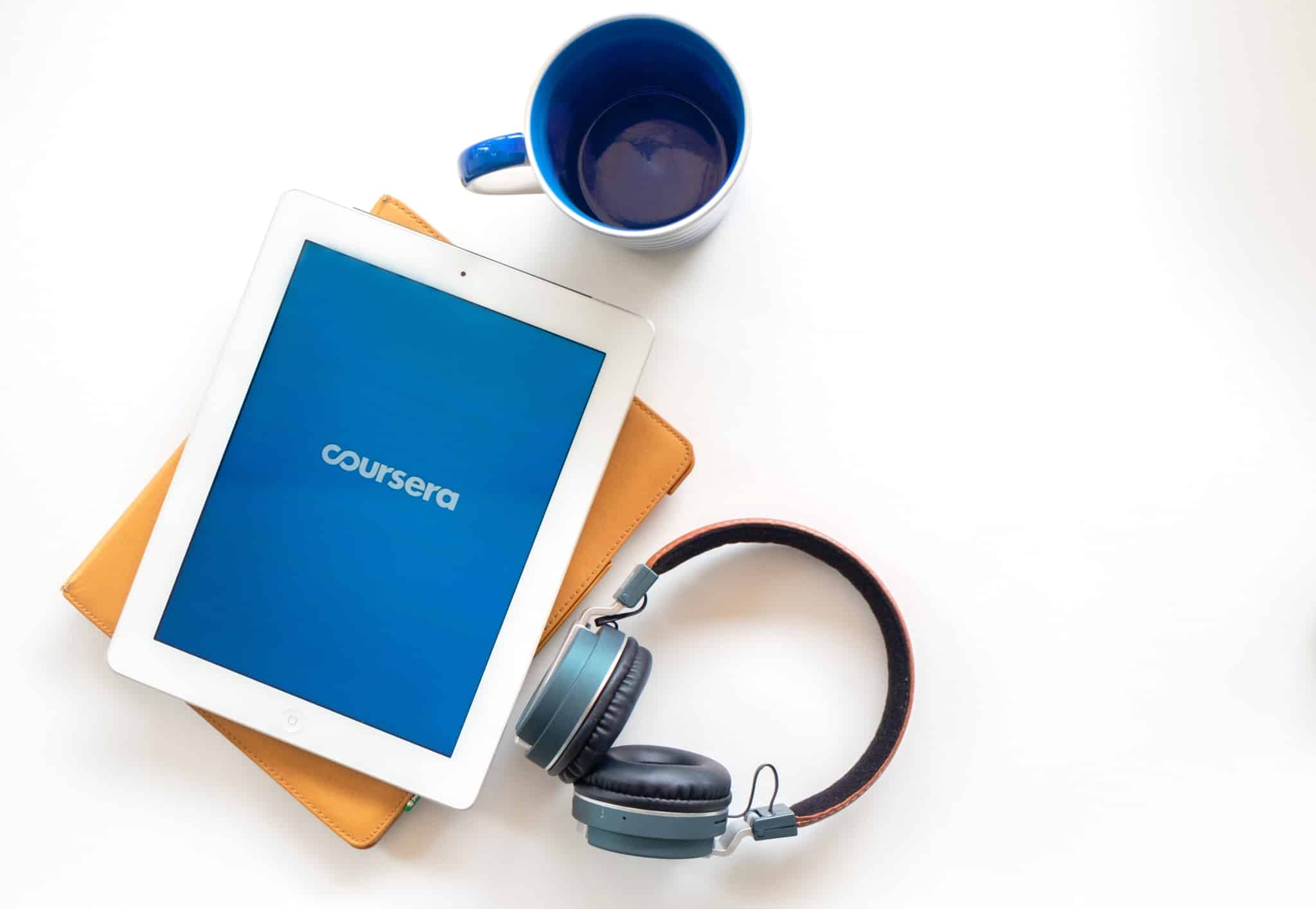 tablet e auscultadores e uma chávena de café