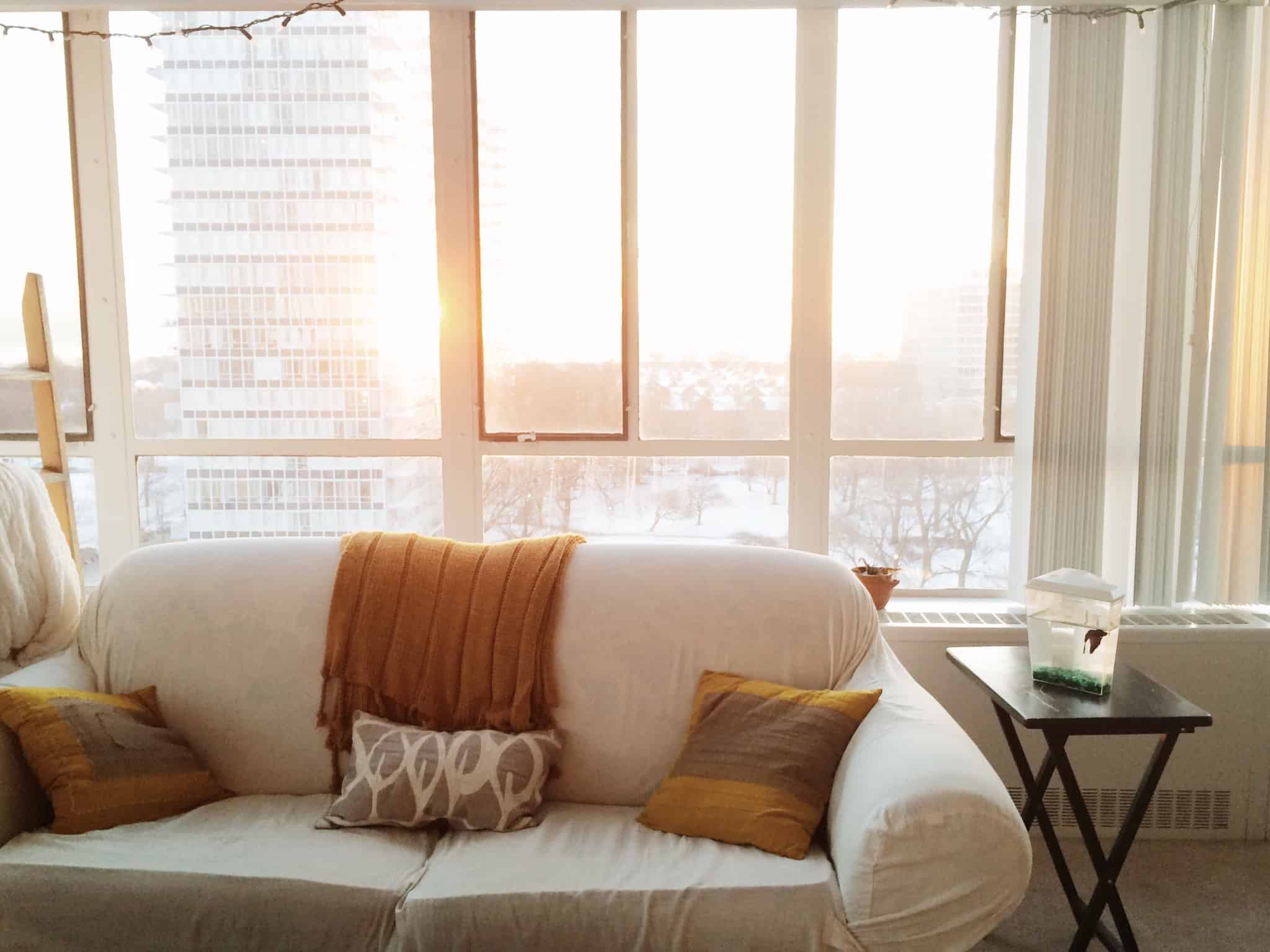 sofa branco encostado a uma janela
