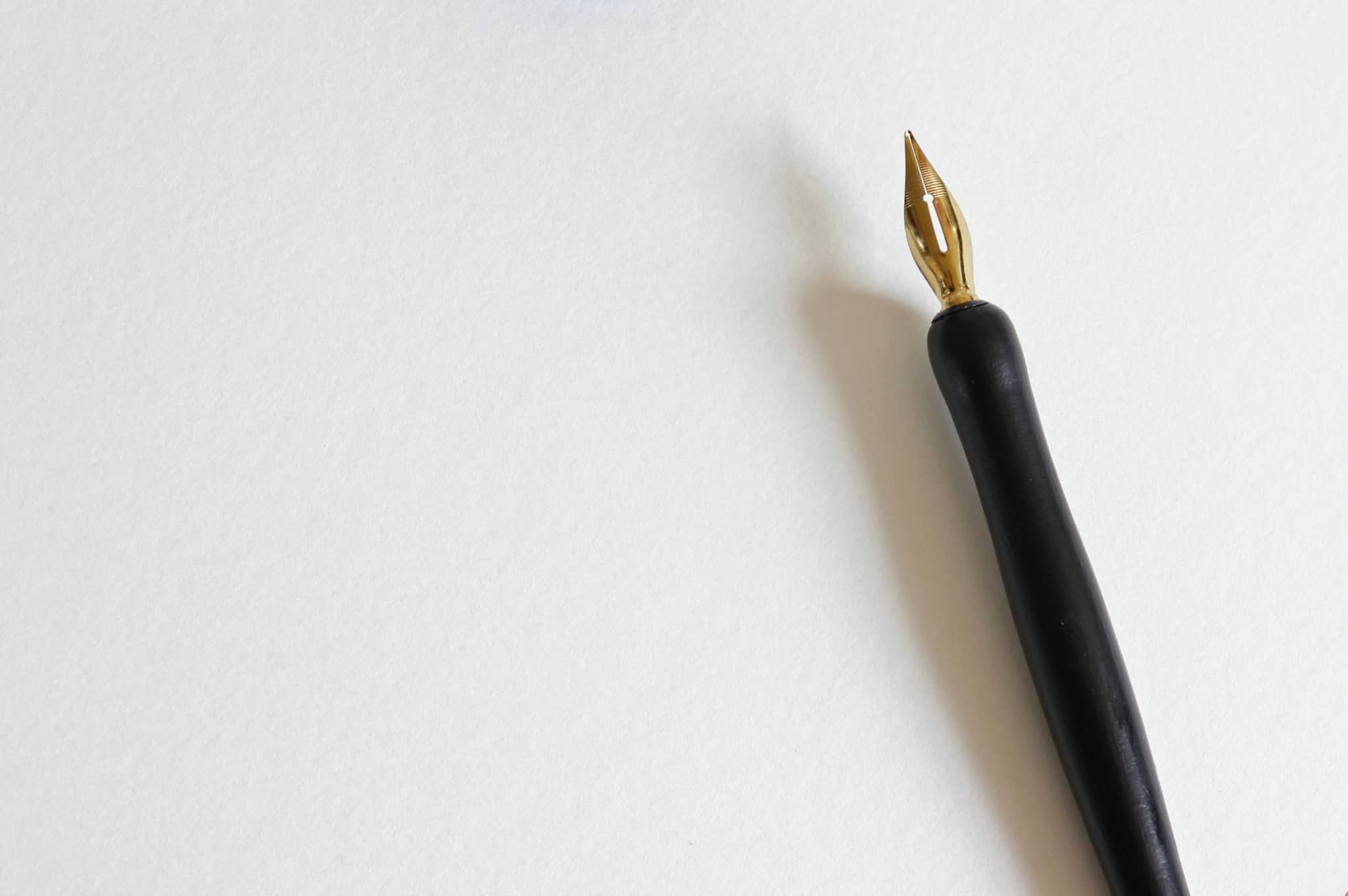caneta profissional em cima de um papel branco