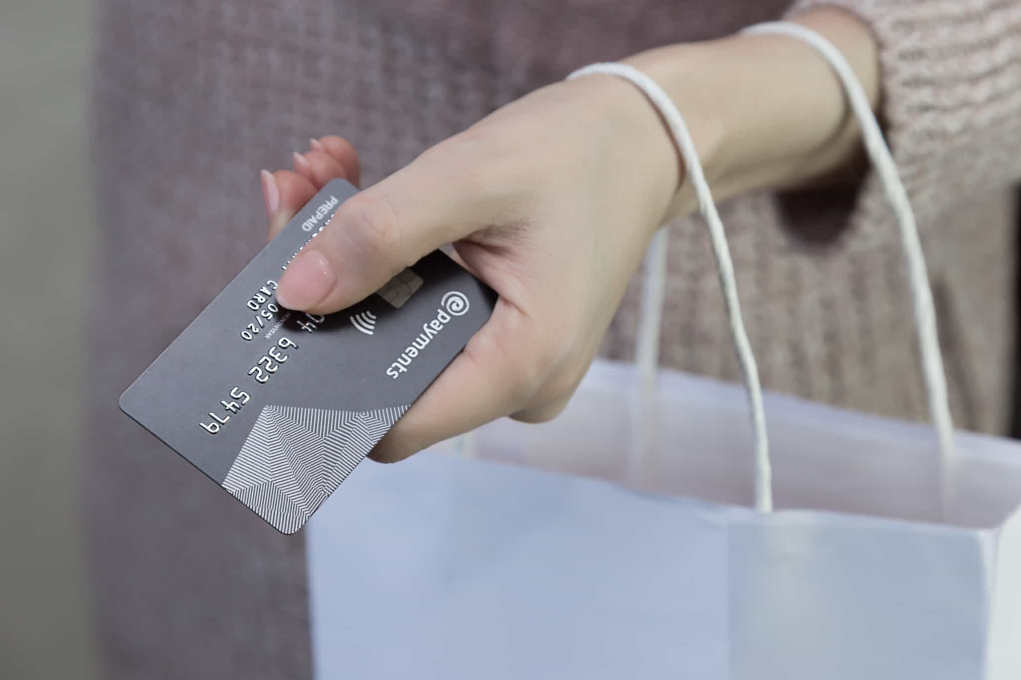 senhora a segurar o cartão de pagamentos na mão