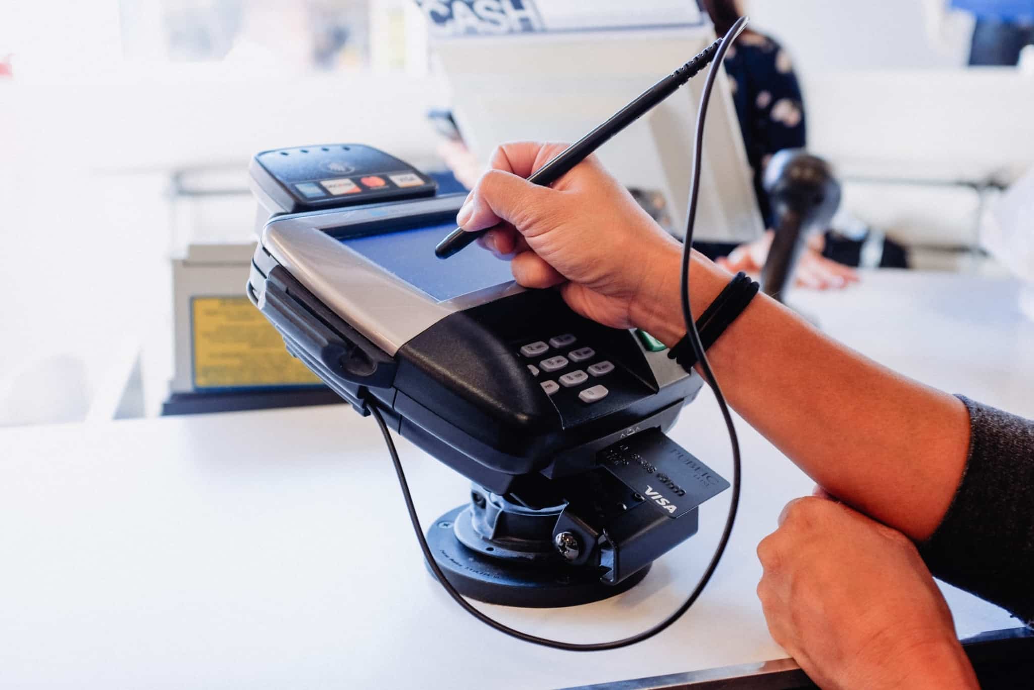 cliente a assinar num posto de pagamento de multibanco