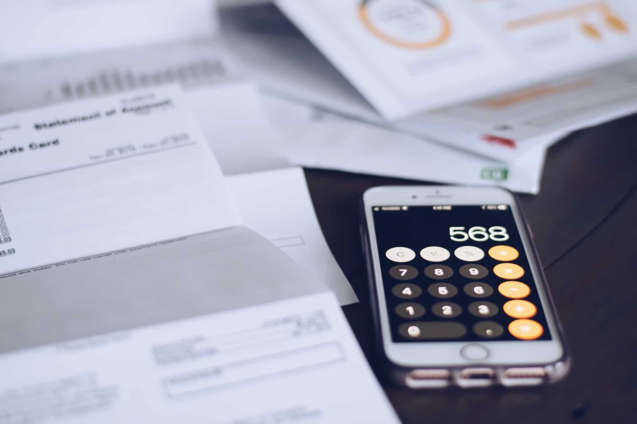 várias faturas e um telemóvel com calculadora