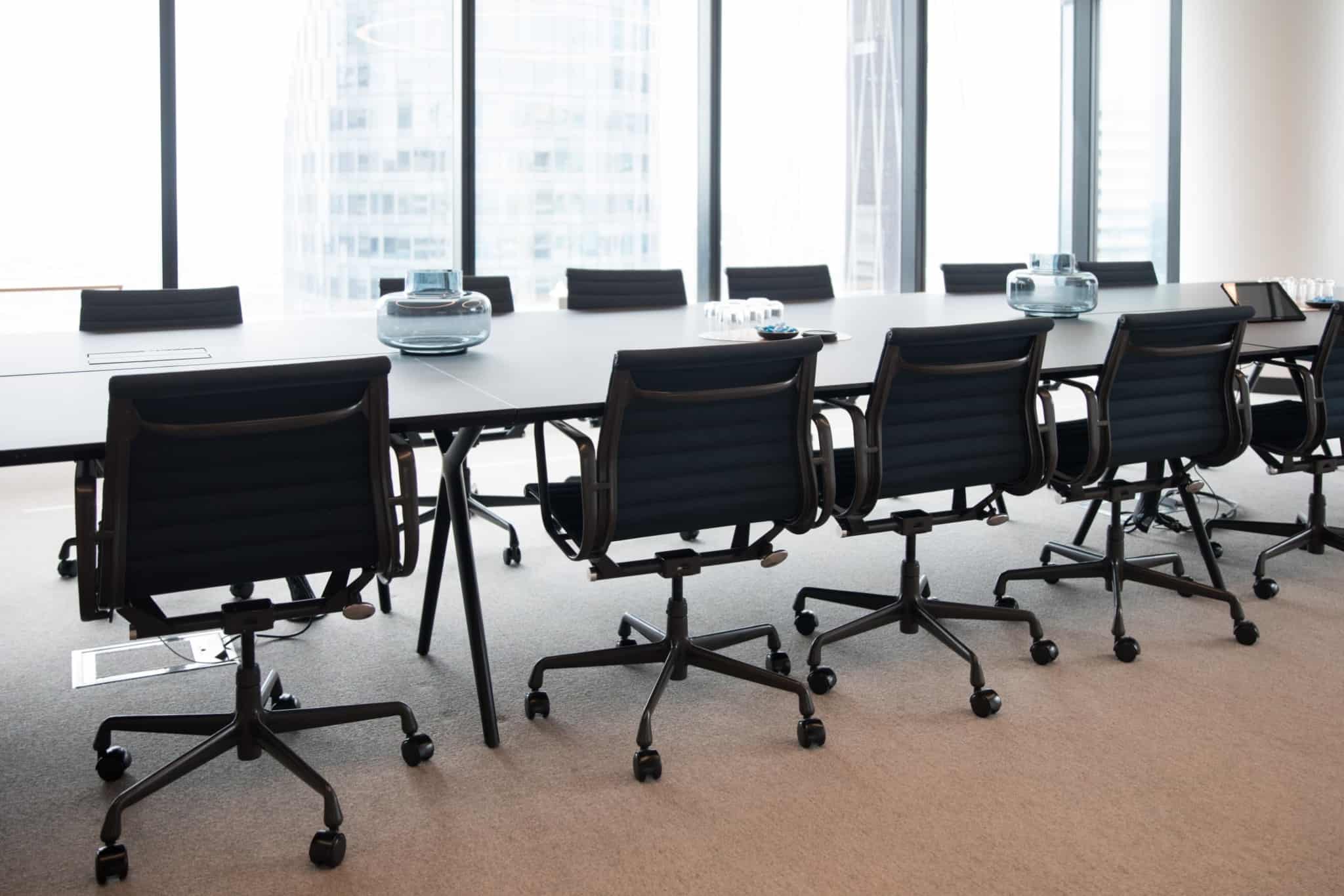 sala de reuniões com cadeiras pretas de cada lado