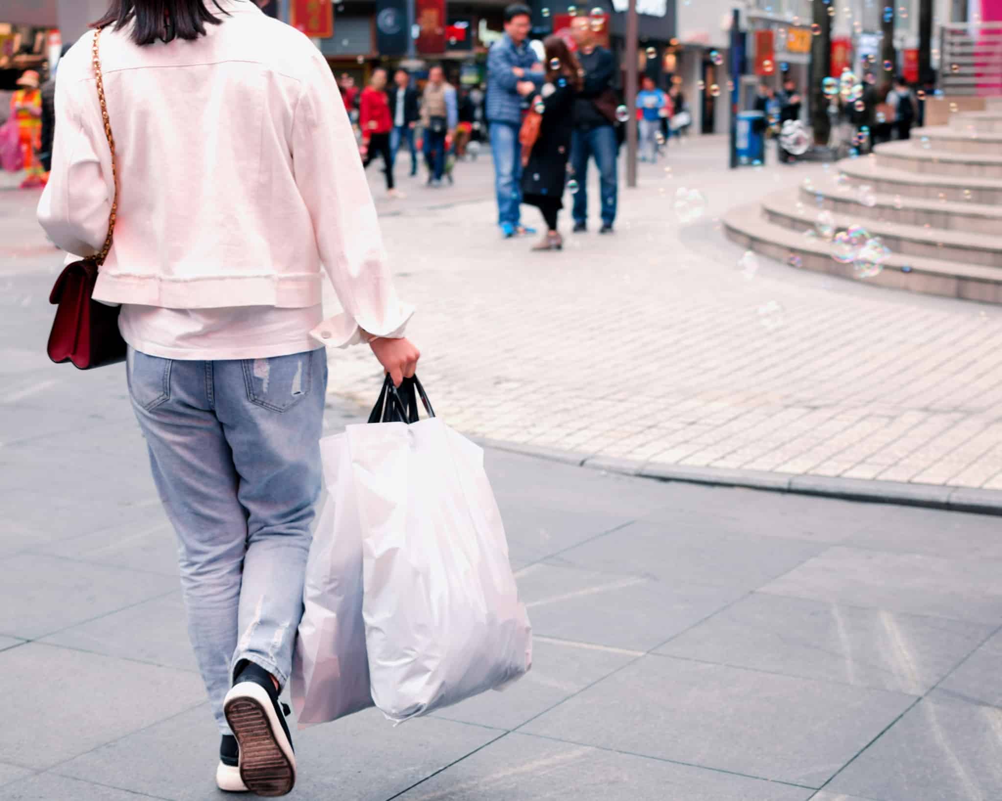 pessoa a andar com sacos de compras