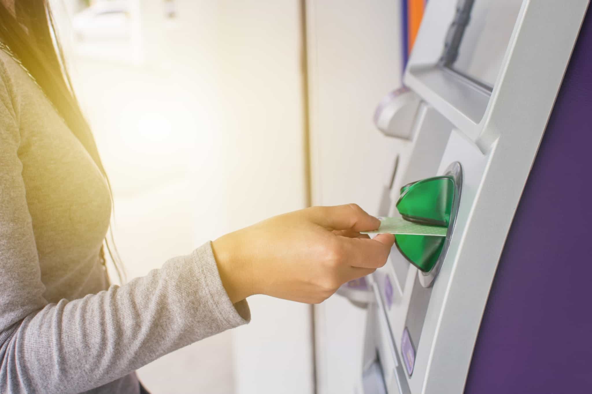 rapariga a colocar cartão no multibanco