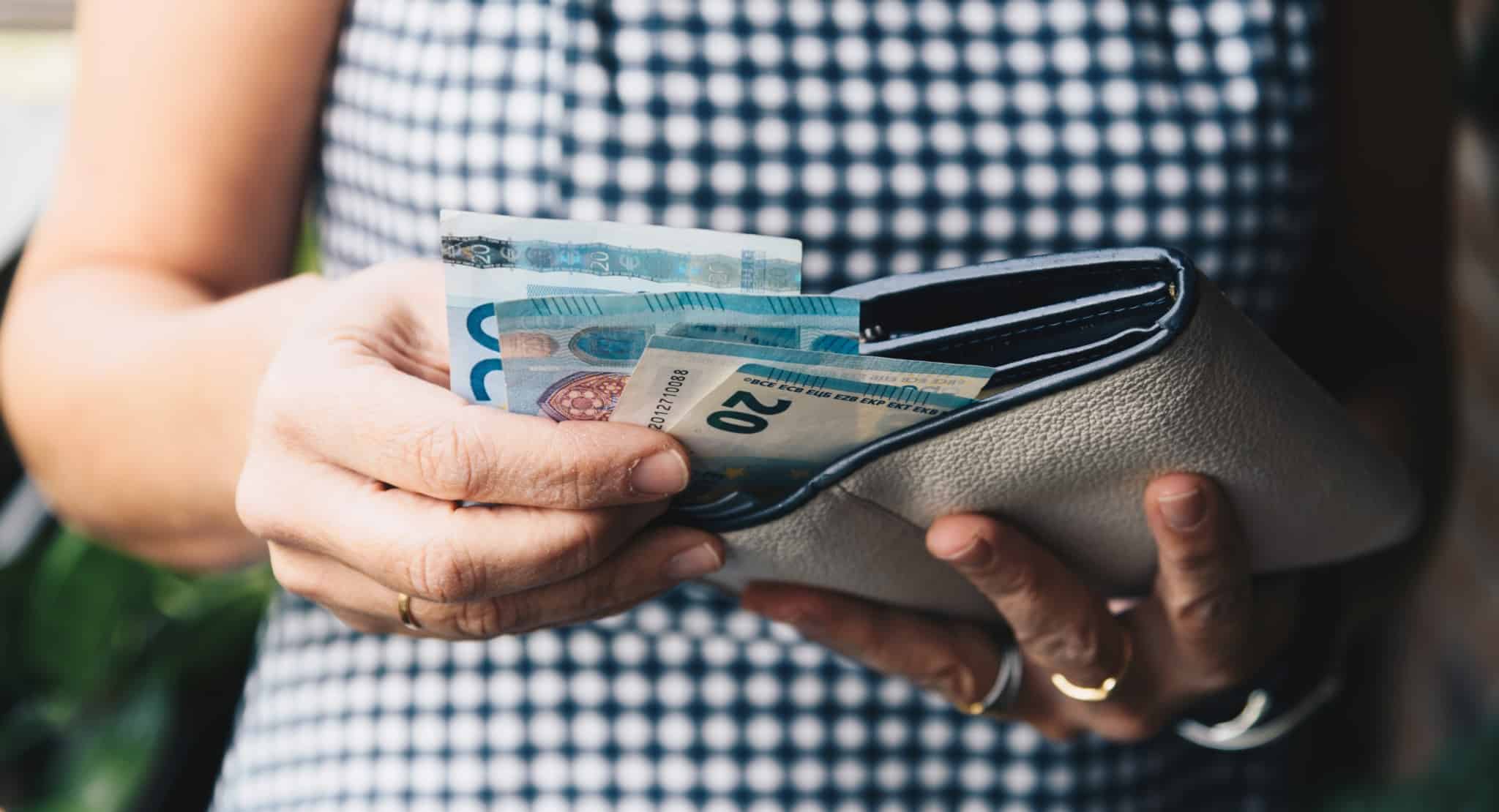 mulher com carteira aberta e notas de vinte euros