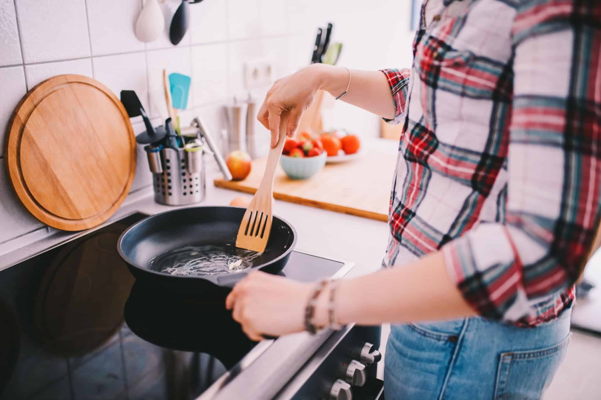 rapariga a cozinhar na frigideira