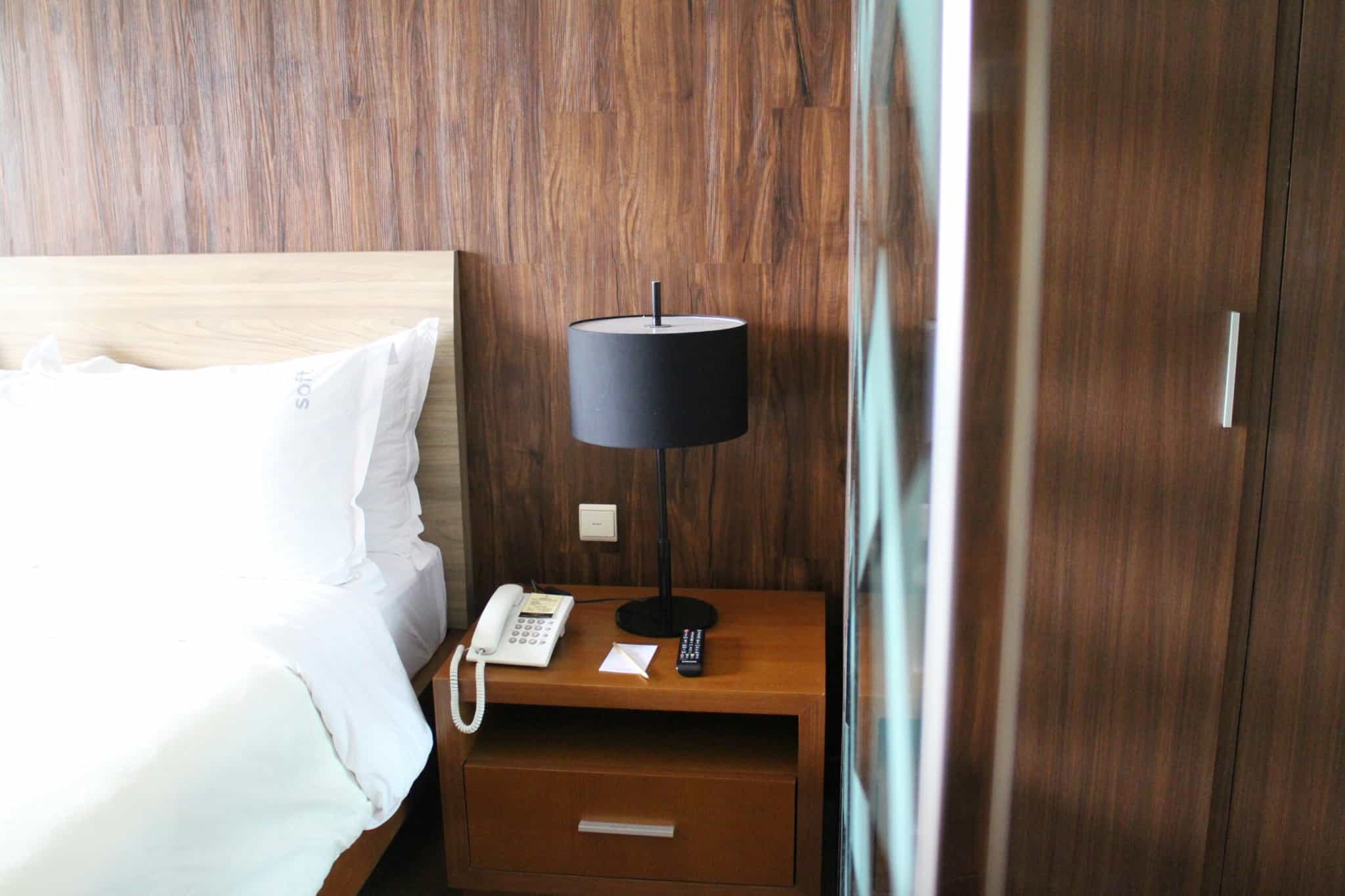 quarto de hotel com cama e candeeiro preto