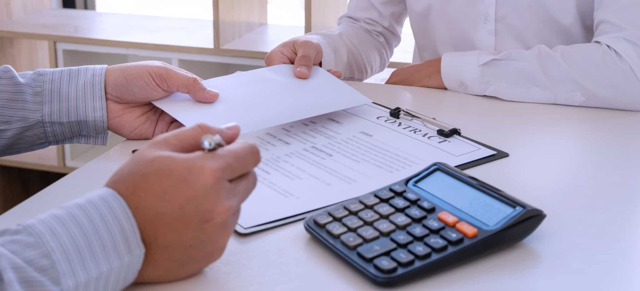 dois homem a fechar um negócio com um envelope, uma calculadora