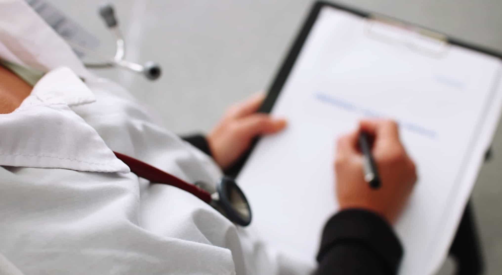 Médica a assinar papéis