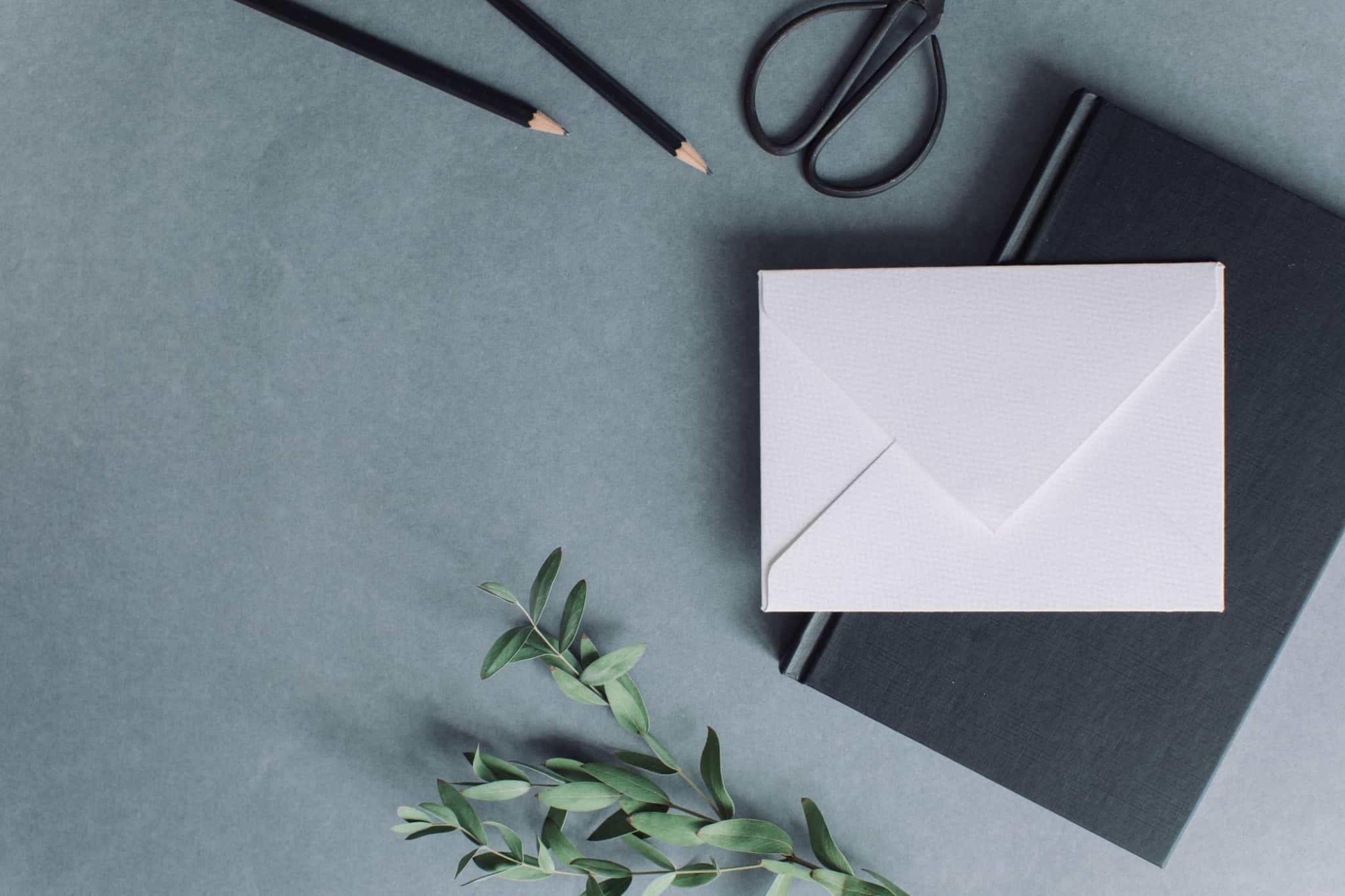 envelope branco em cima de um caderno preto