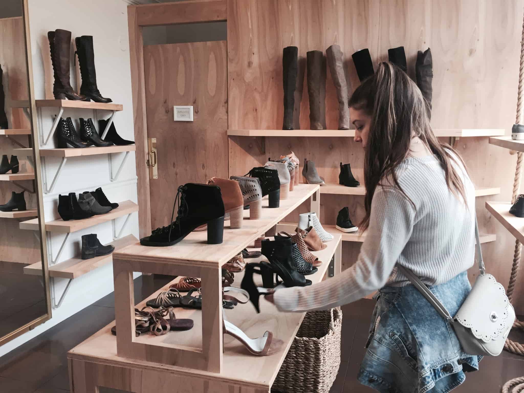 rapariga a ver uns sapatos pretos numa pequena loja