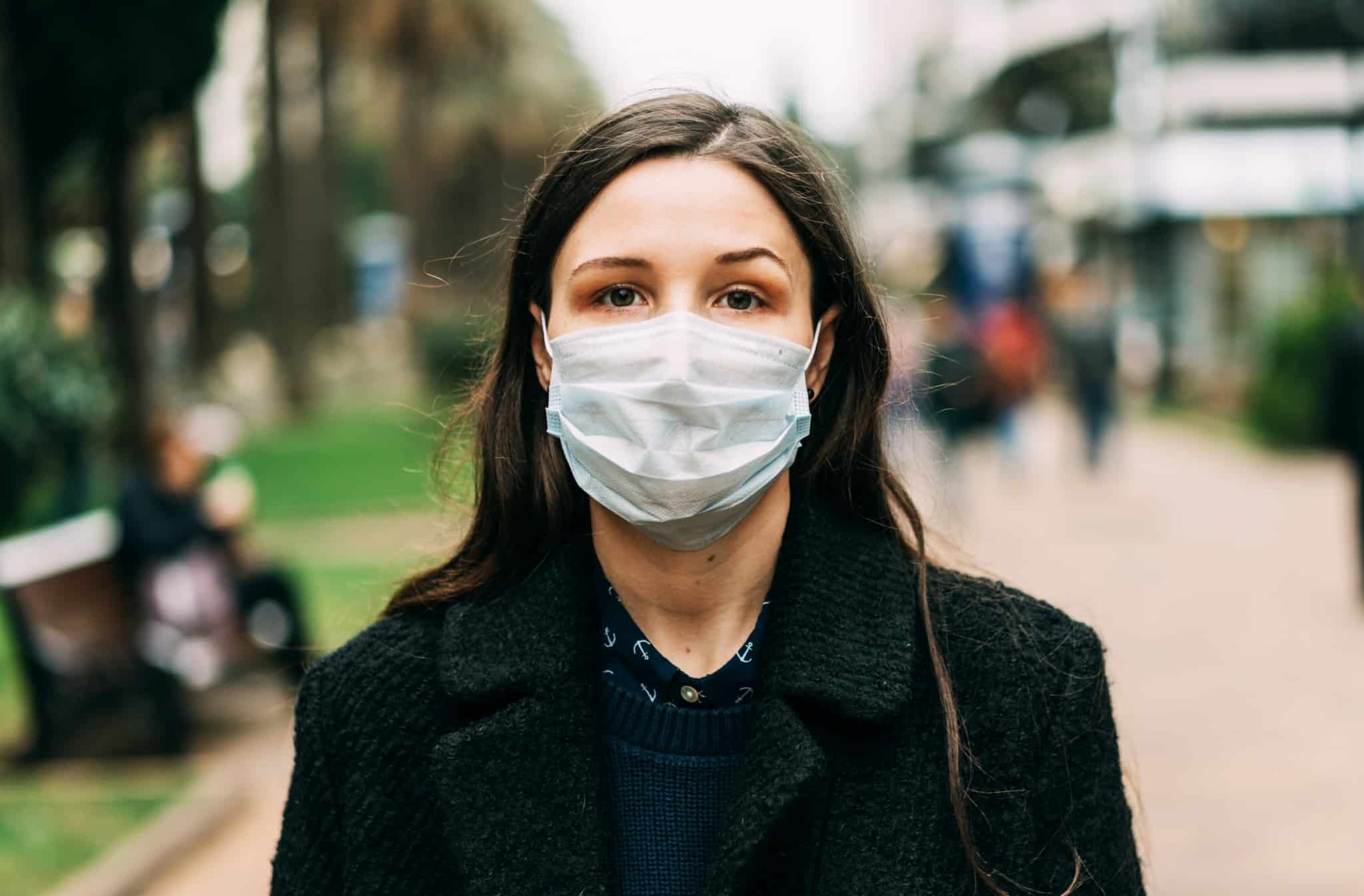 mulher na rua com máscara facial