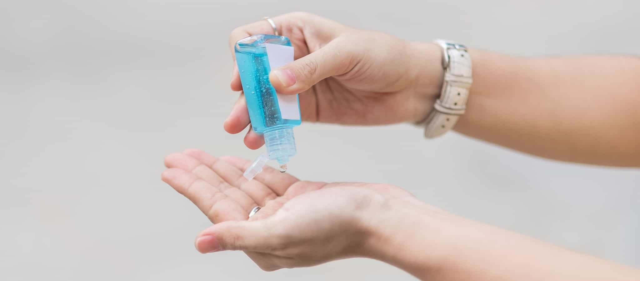 mulher a colocar gel desinfetante nas mãos