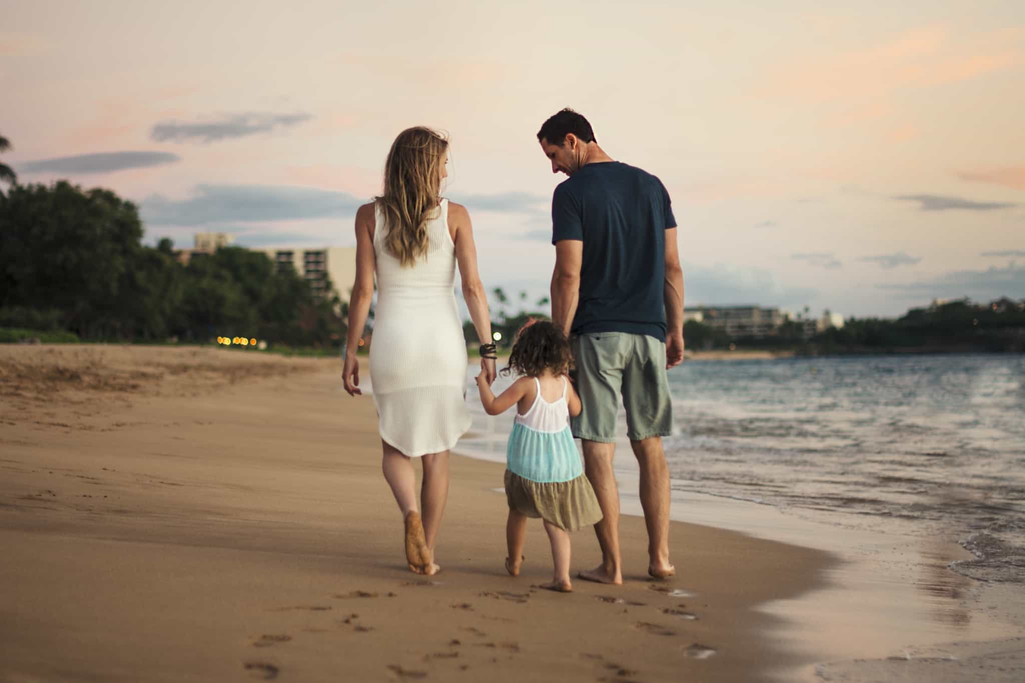 casal a passear na praia com a filha