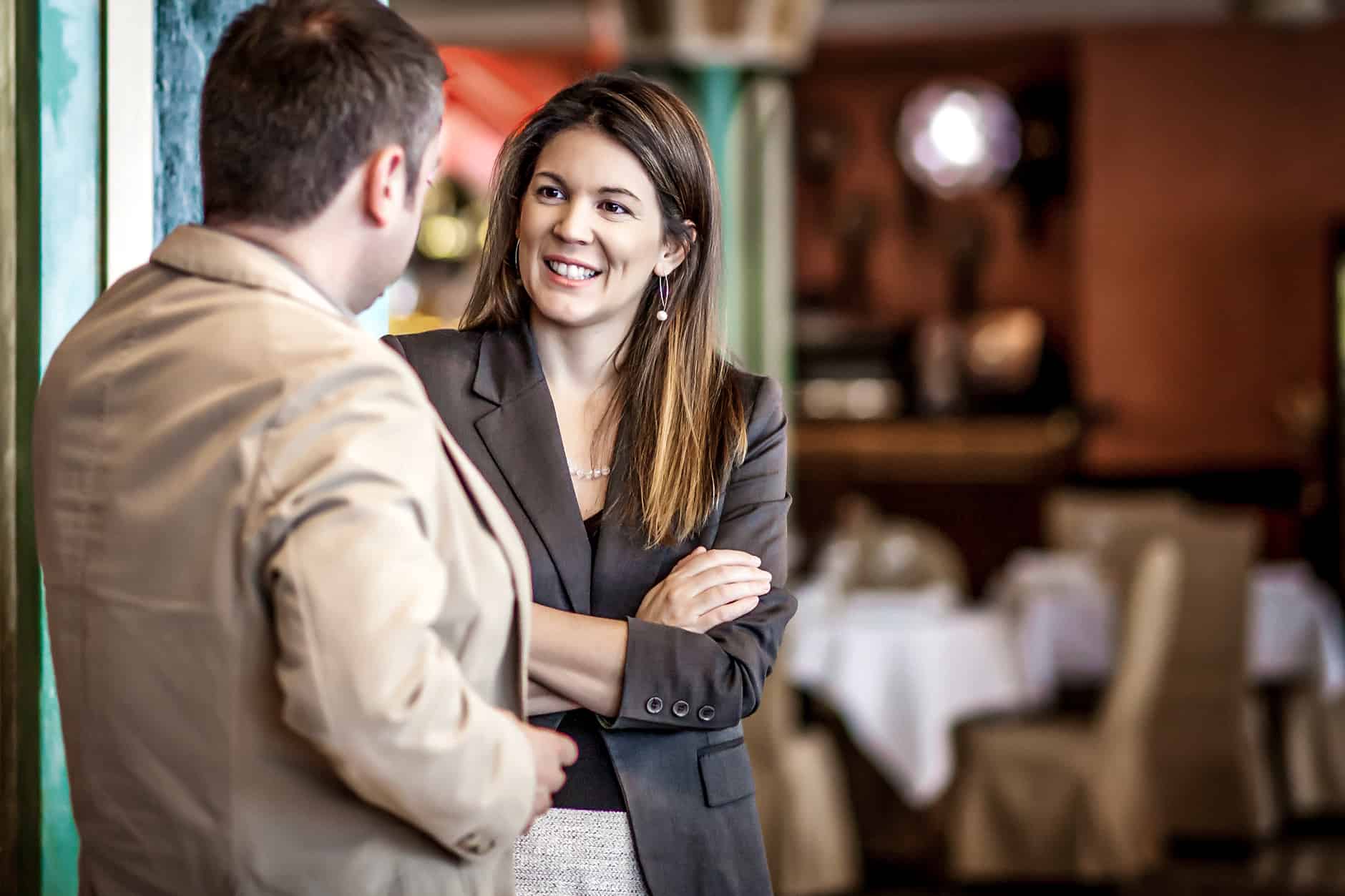 dois jovens, uma mulher e um homem, trocam conhecimentos em ambiente de networking profissional