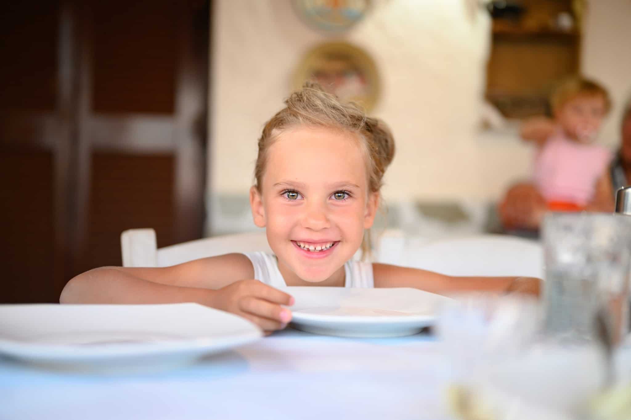 rapariga loira a comer à mesa