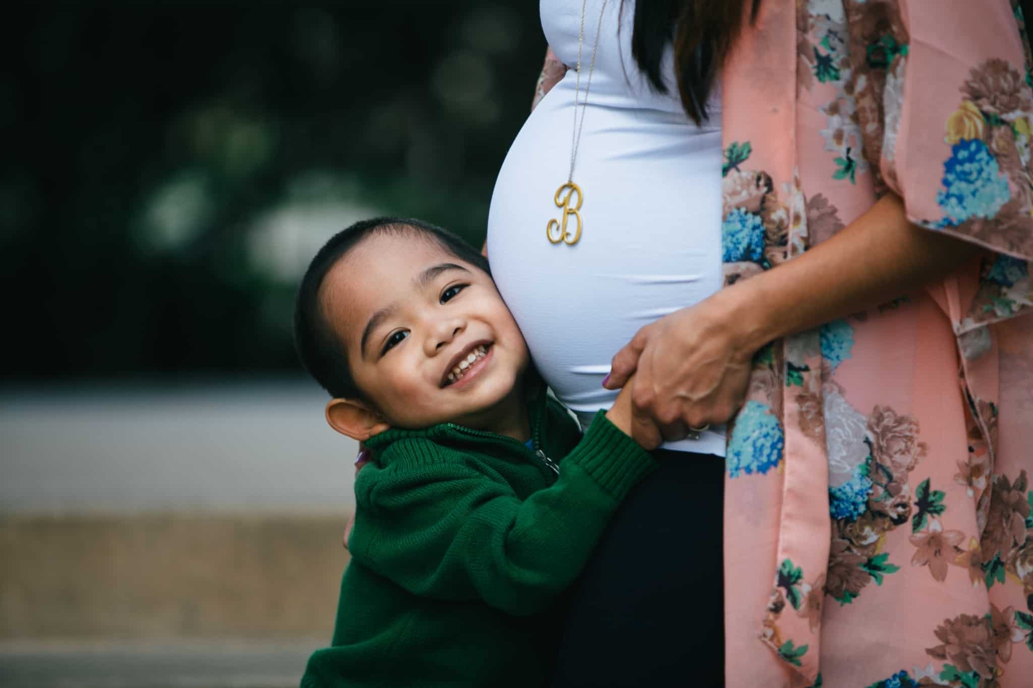 mae grávida a segurar o filho mais novo