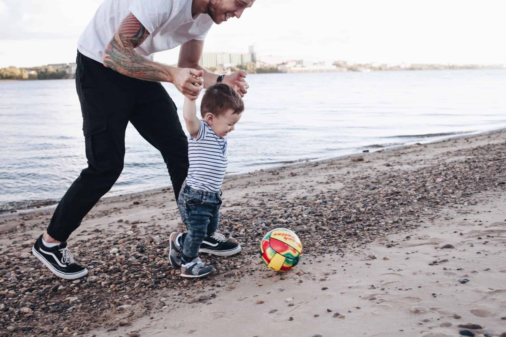 pai a brincar com o filho na praia