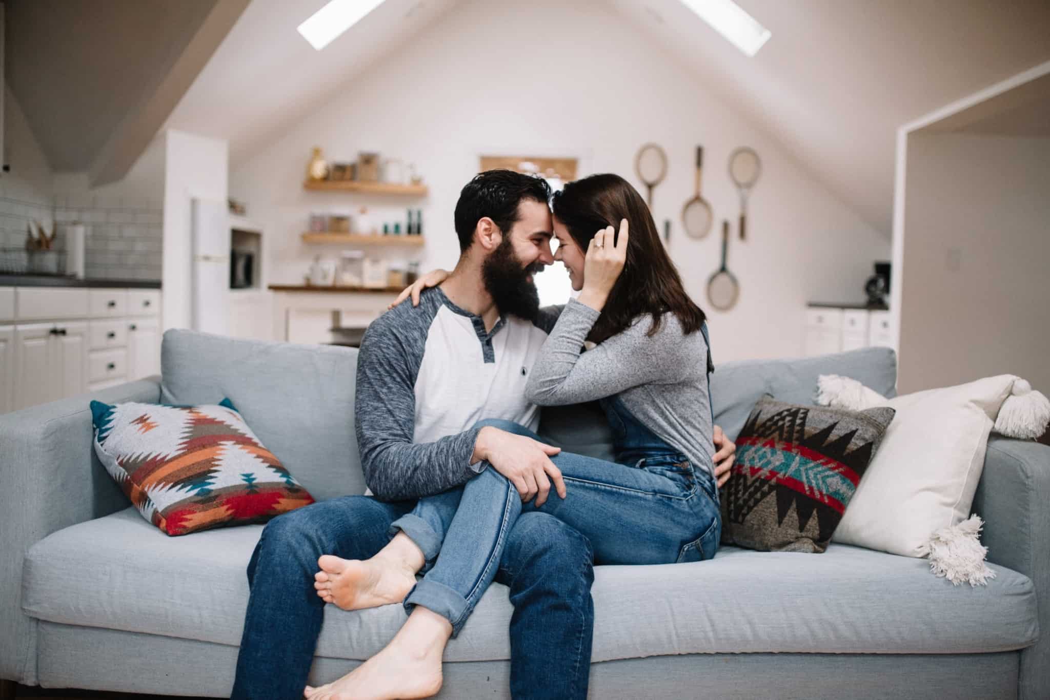 casal feliz sentado no sofá em casa