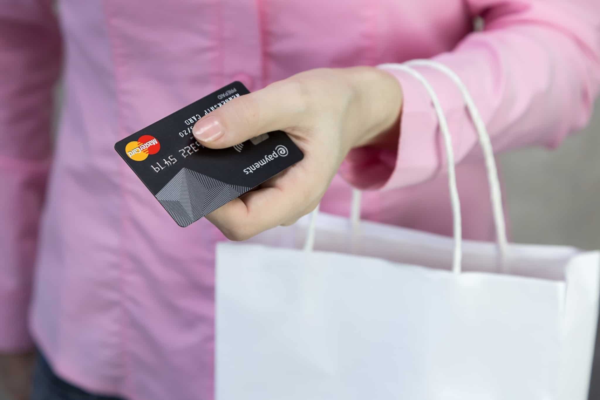 pessoa a segurar cartão de crédito preto