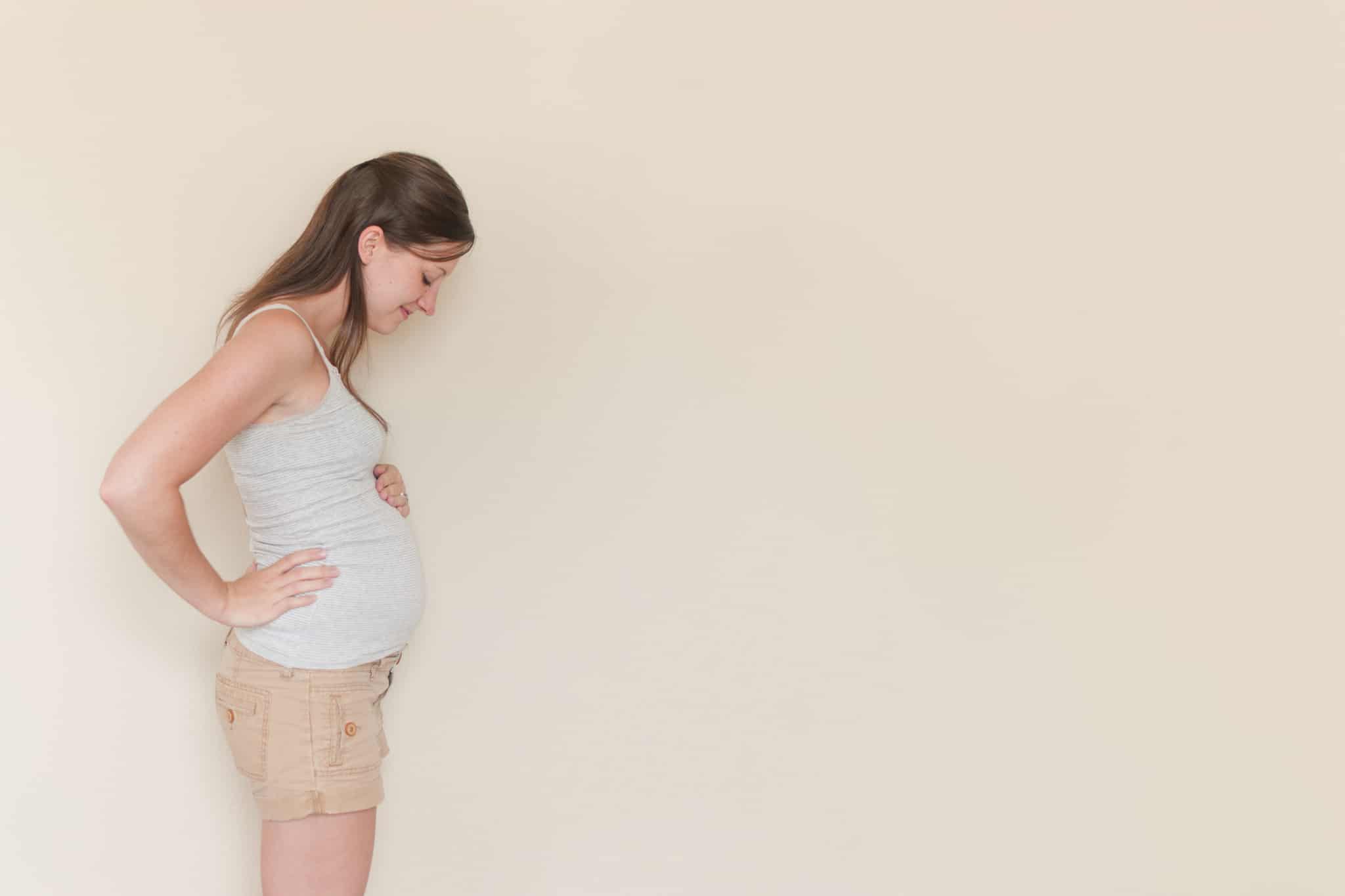 mulher grávida em pé com calçoes