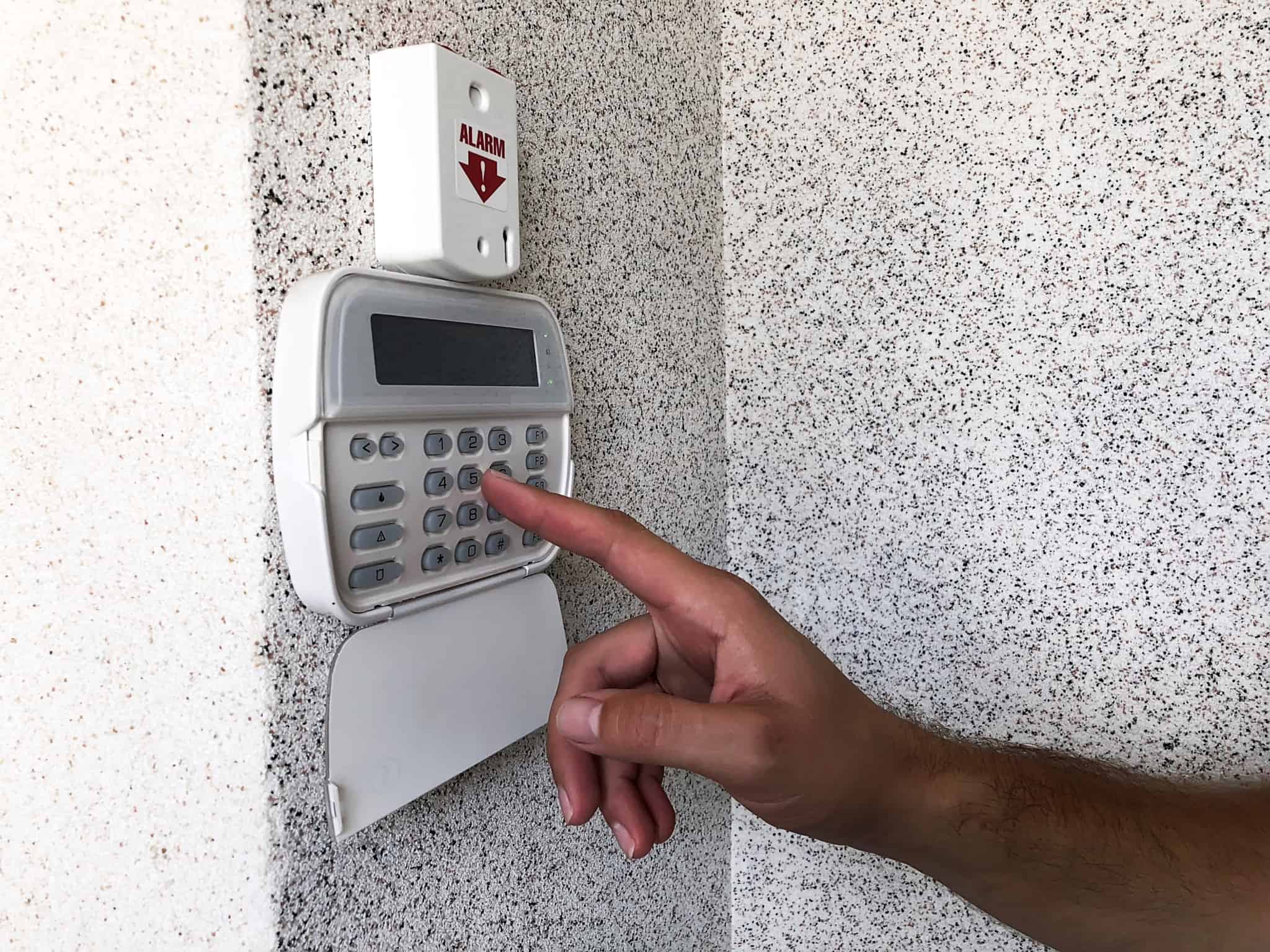pessoa a colocar o alarme de casa ao digitar numeros