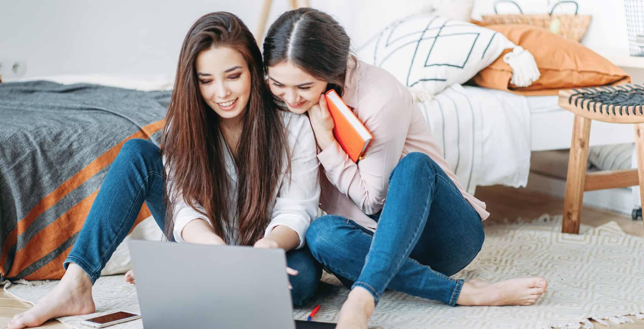 Duas raparigas em casa a trabalhar com o computador