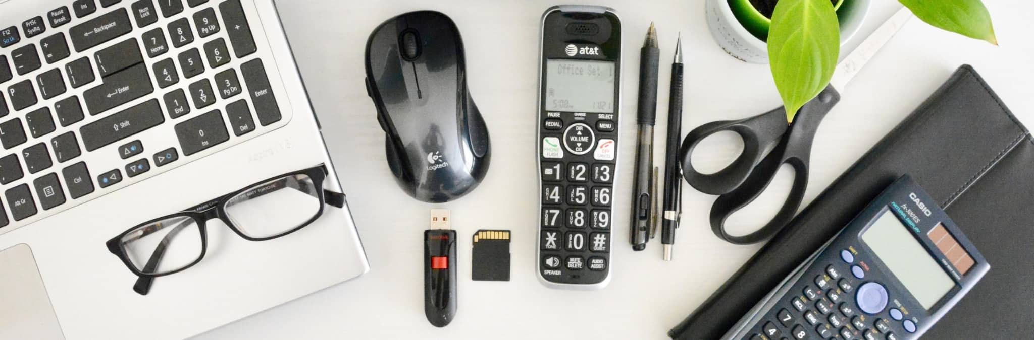 Secretária com computador, telefone e calculadora