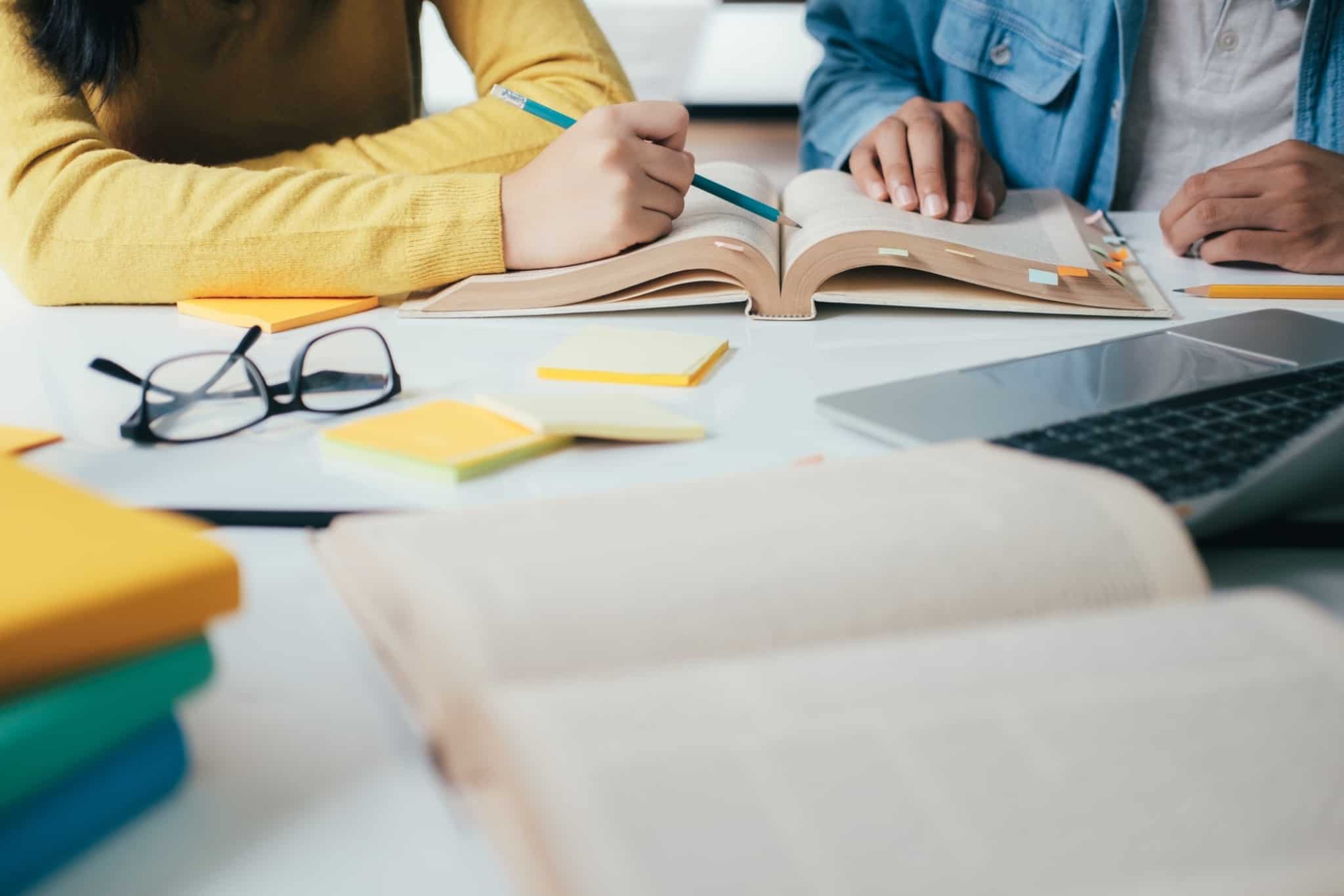 Duas pessoas a estudar - mesa com livros