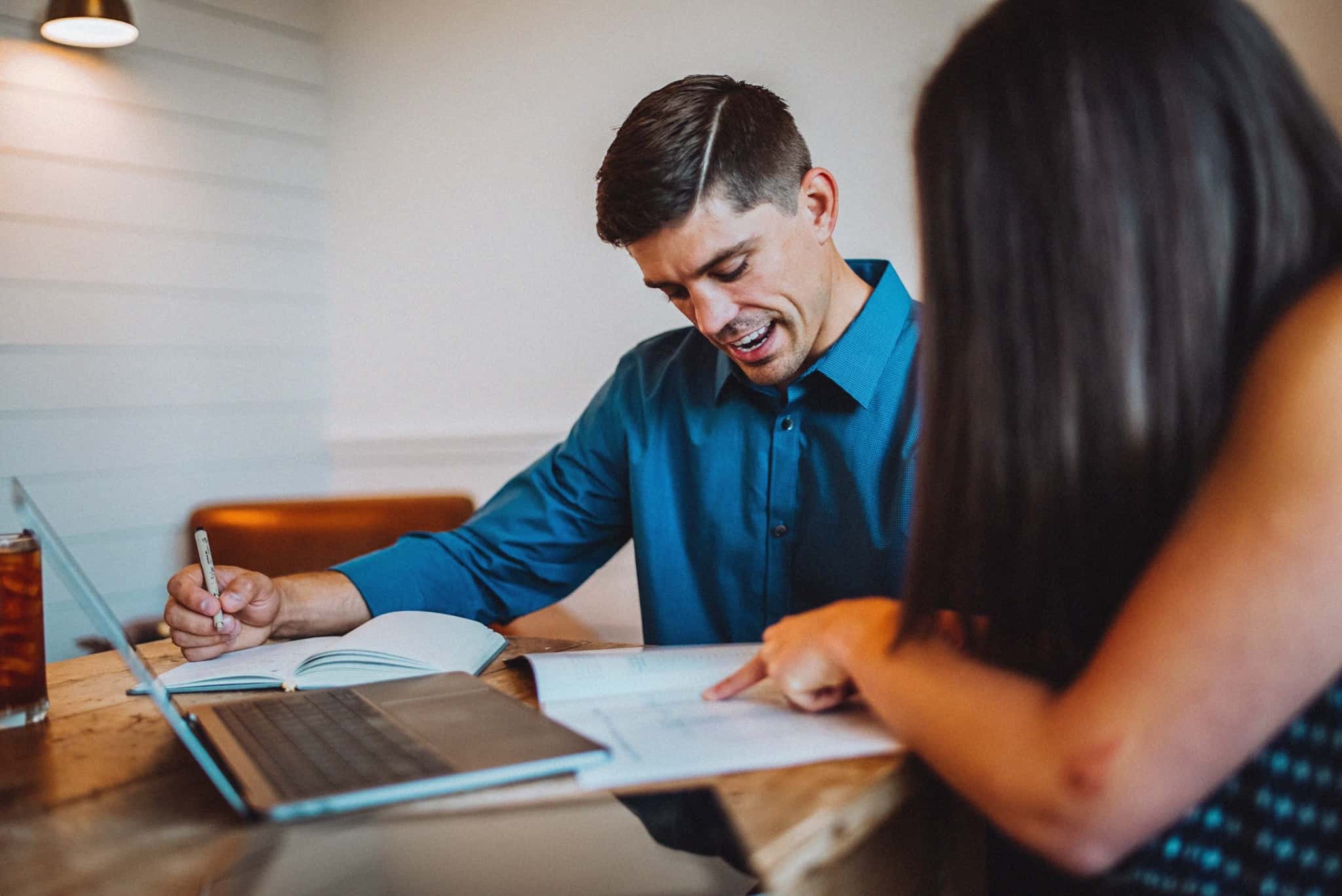 Casal a partilhar ideias e a escrever num bloco de notas