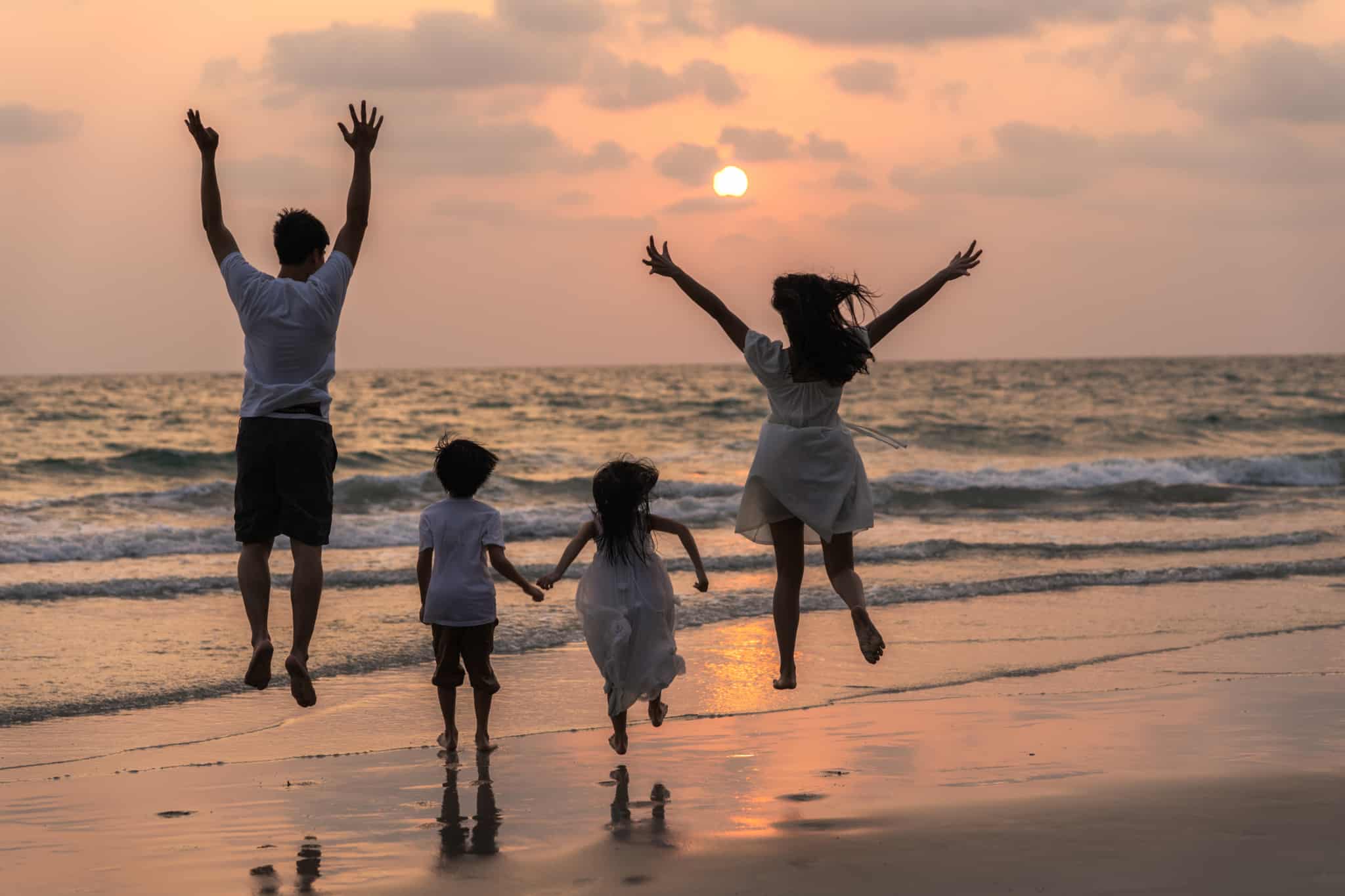 Família brinca à beira-mar