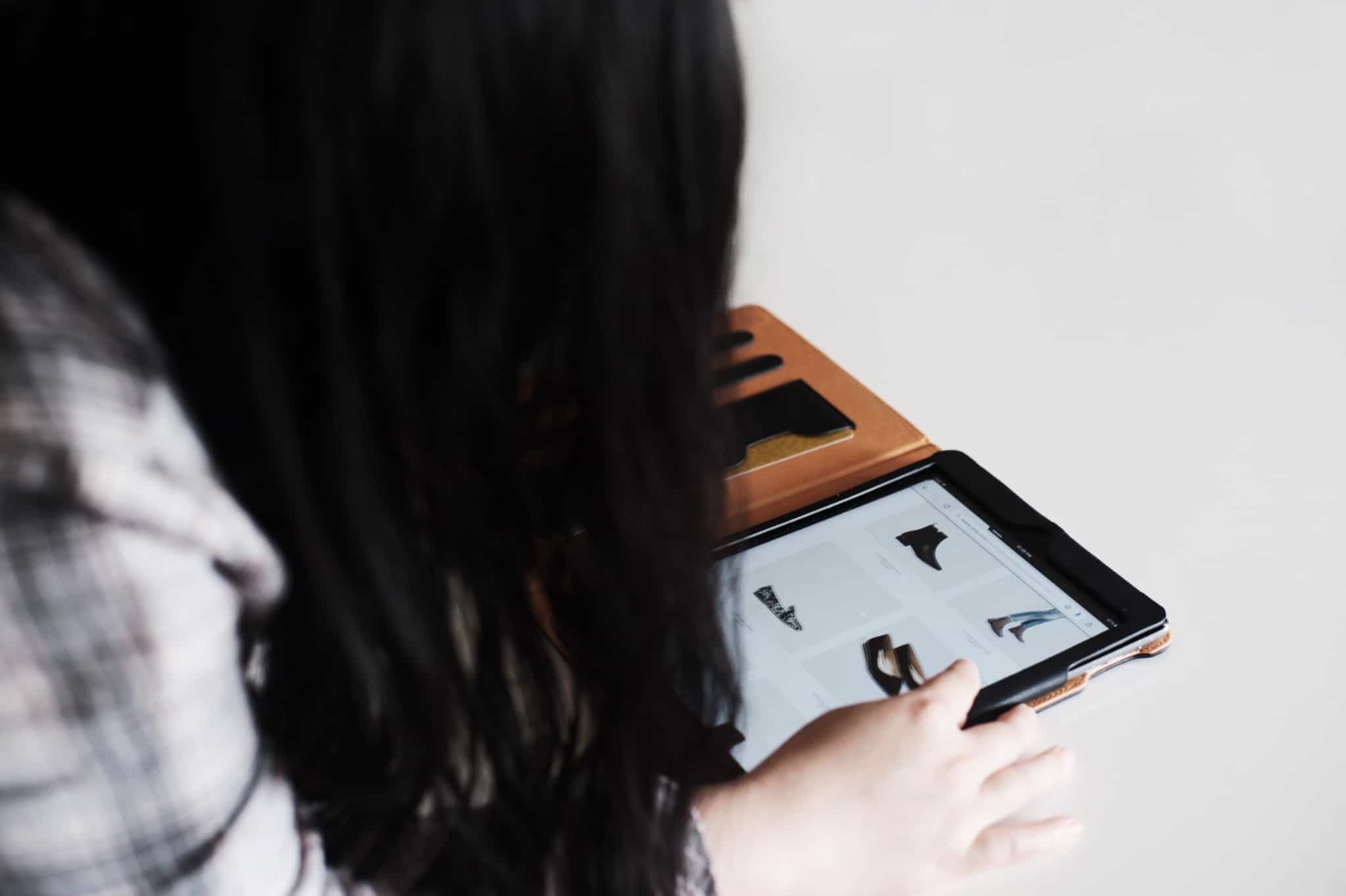 rapariga faz compras de sapatos através do tablet