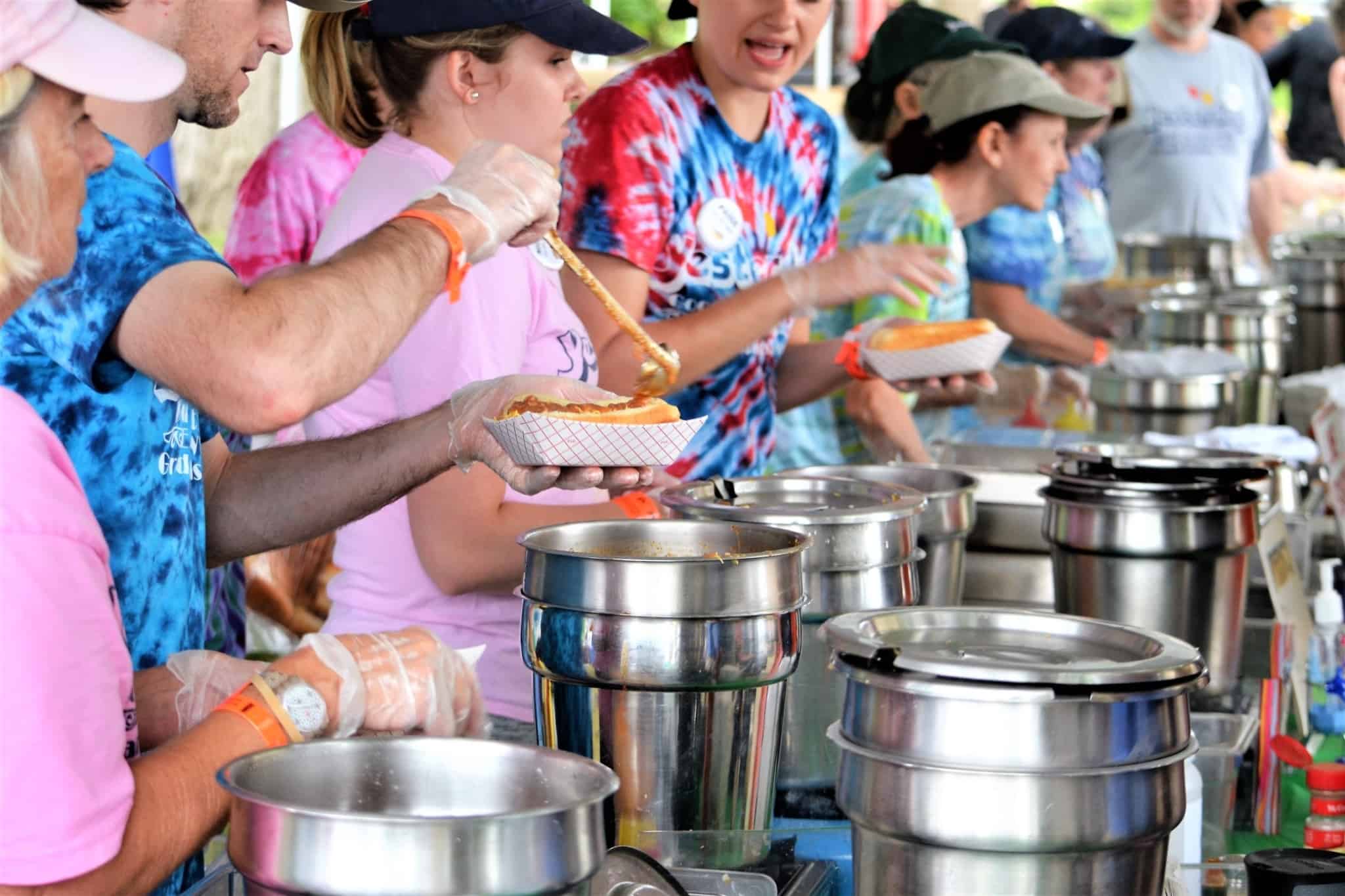 Voluntários cozinham e servem comida a pessoas desfavorecidas