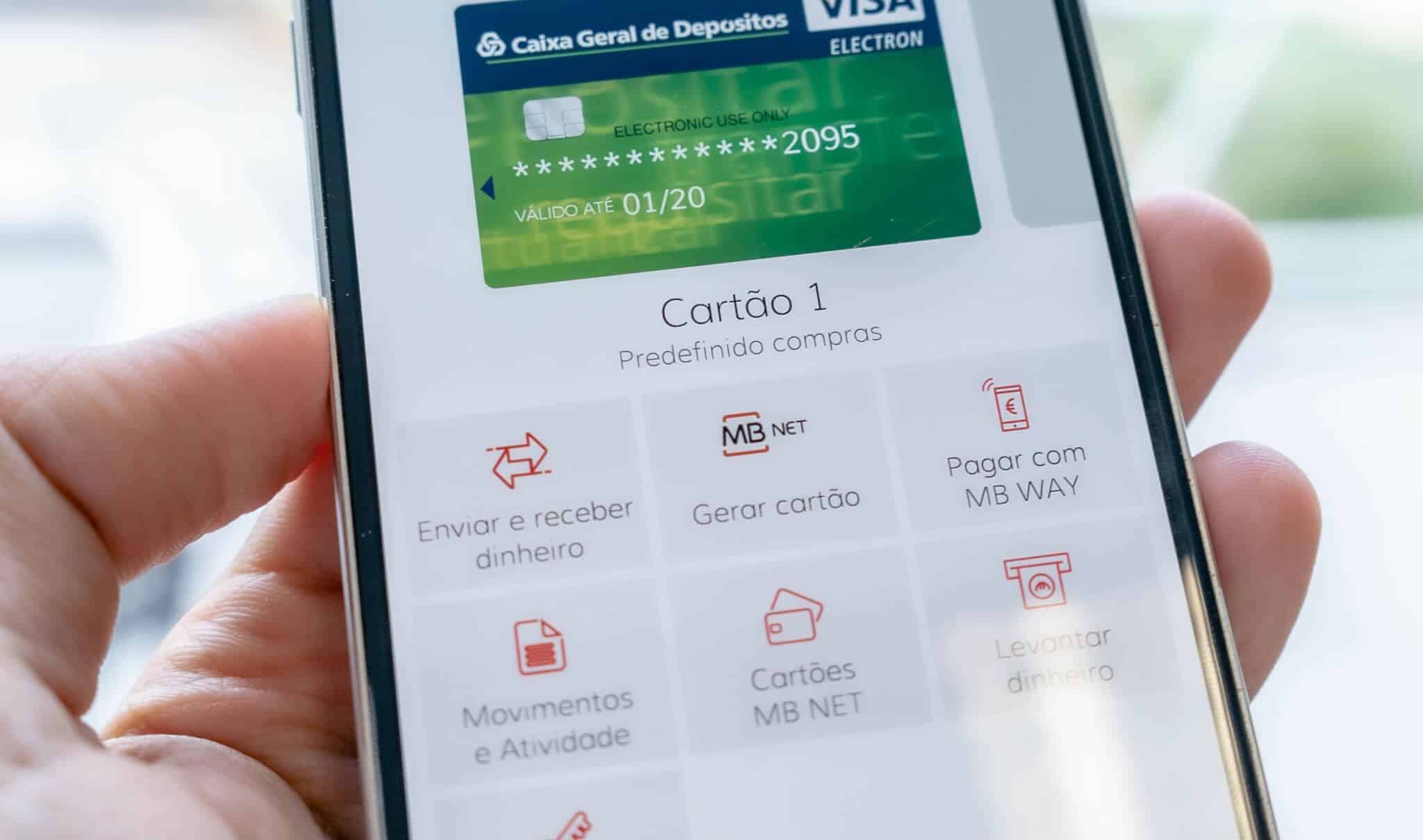 Mão segura num telemóvel com a aplicação do MBWay aberta