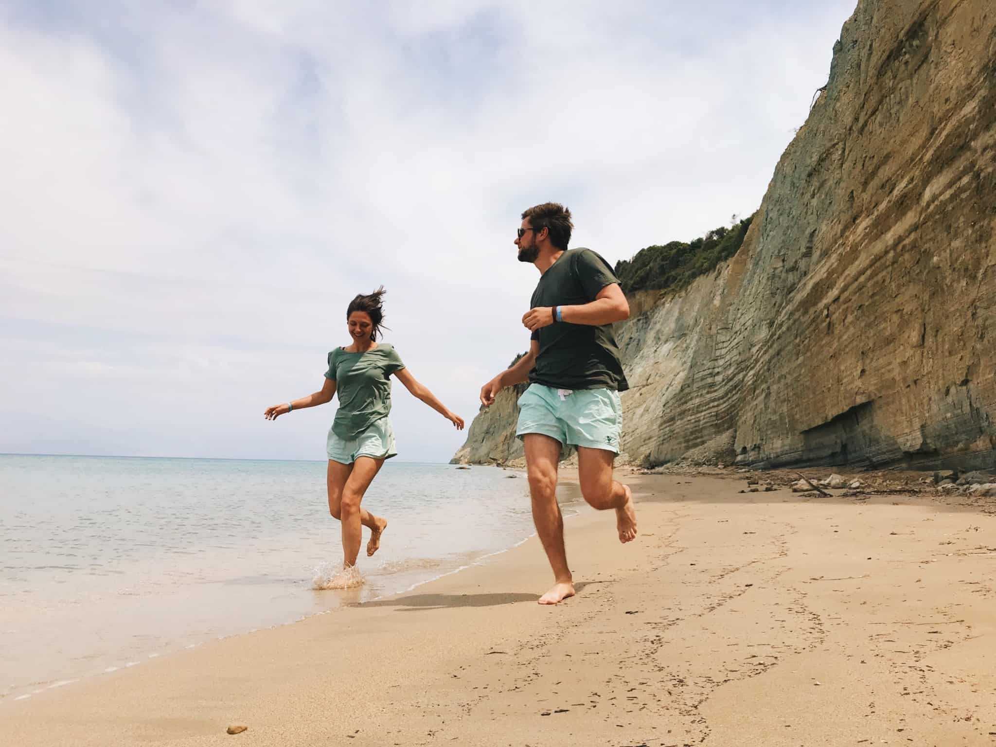 Casal a correr e a divertir-se numa praia