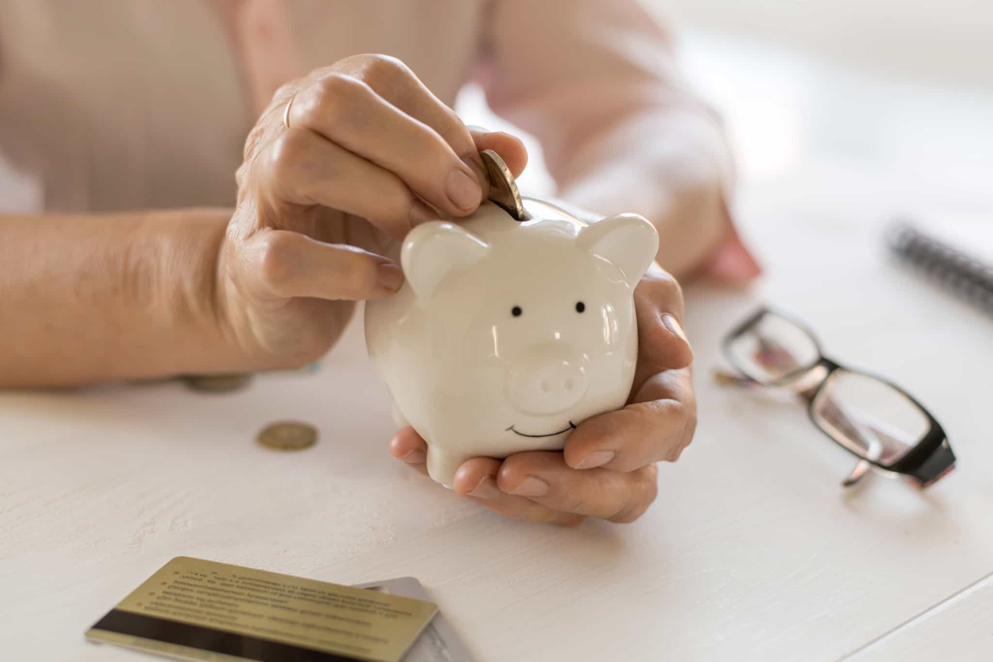 senior a colocar moedas num mealheiro