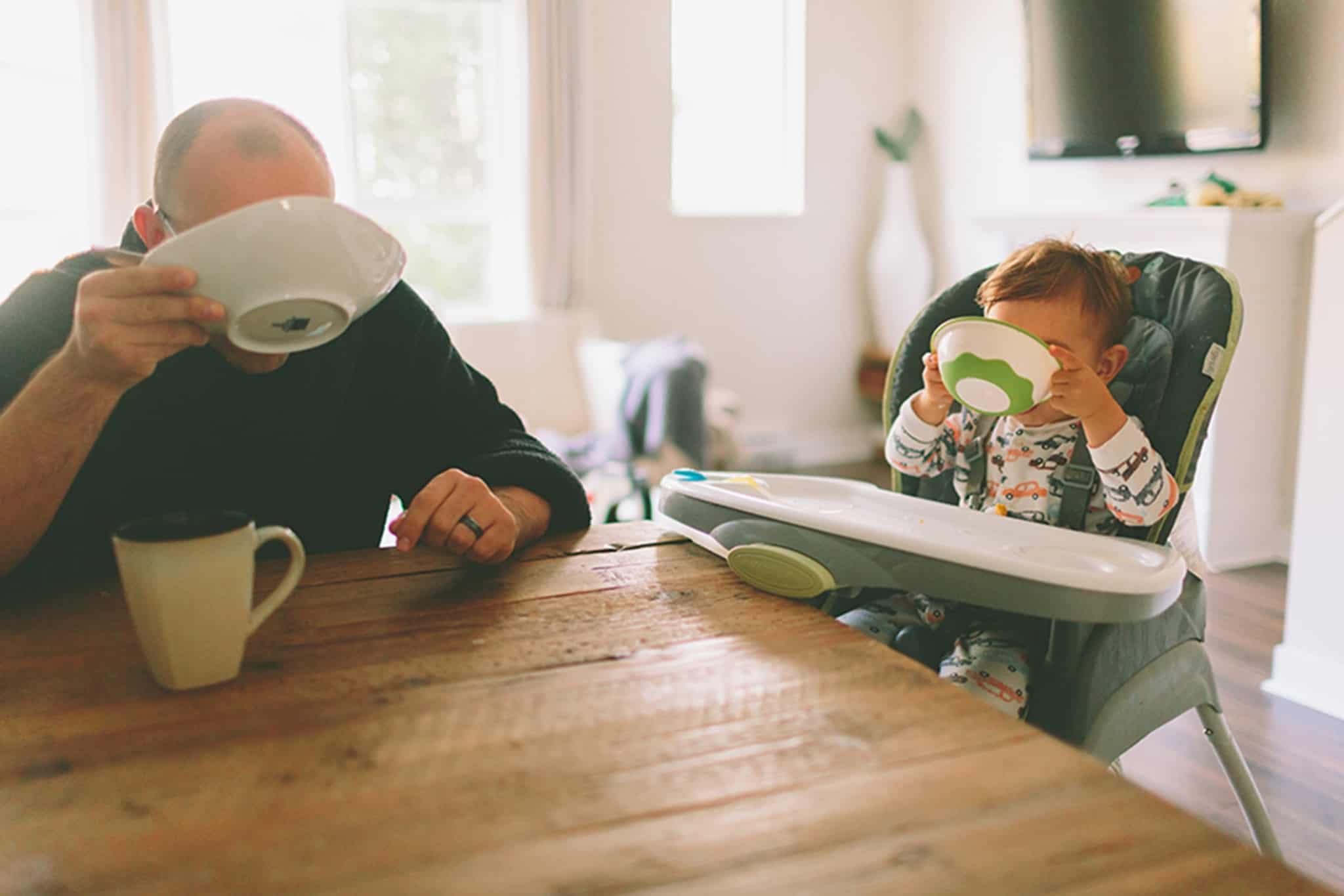 pai e filho terminam de tomar o pequeno-almoço na cozinha