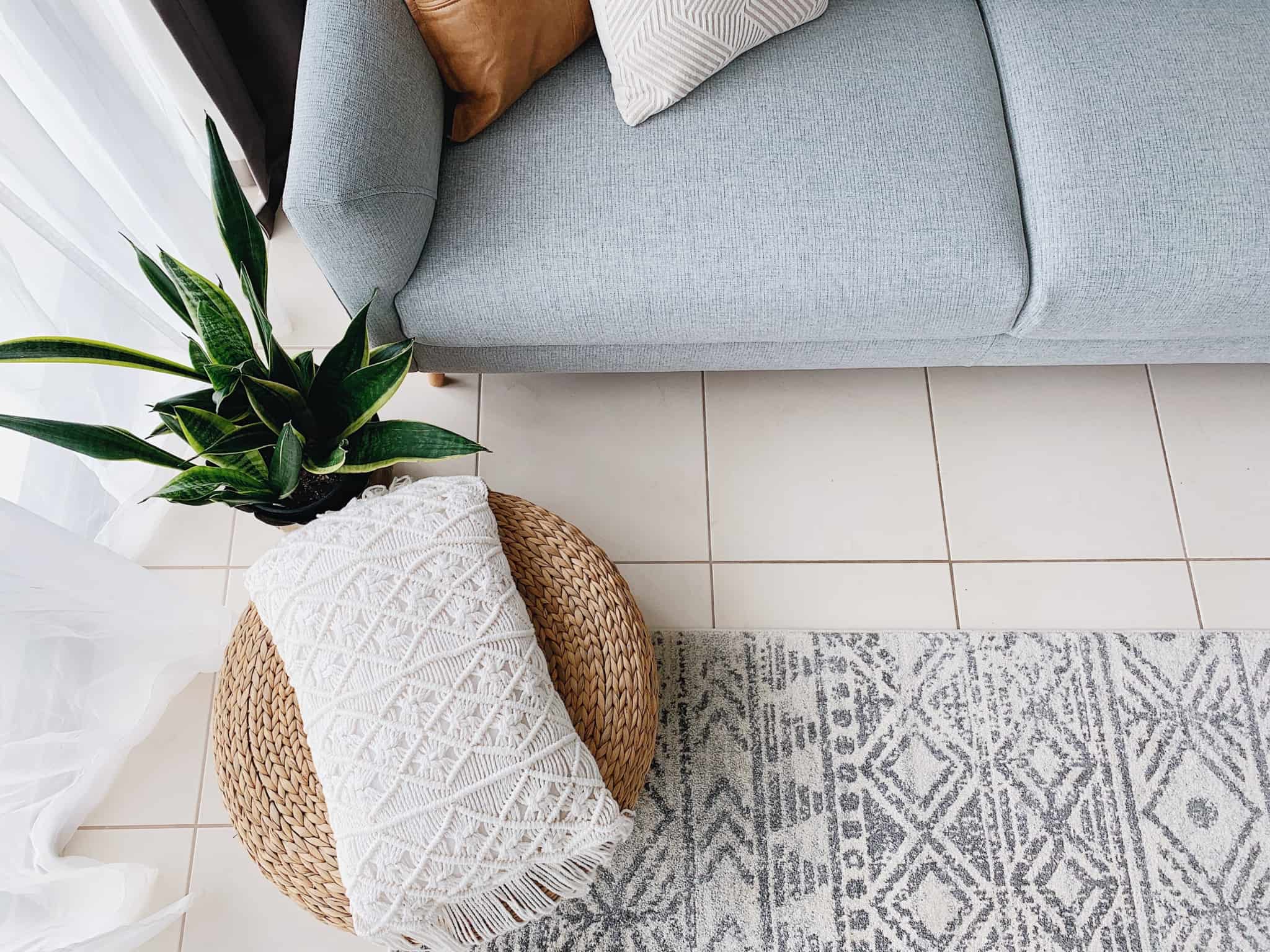 Uma mesa de apoio e uma planta junto de um sofá