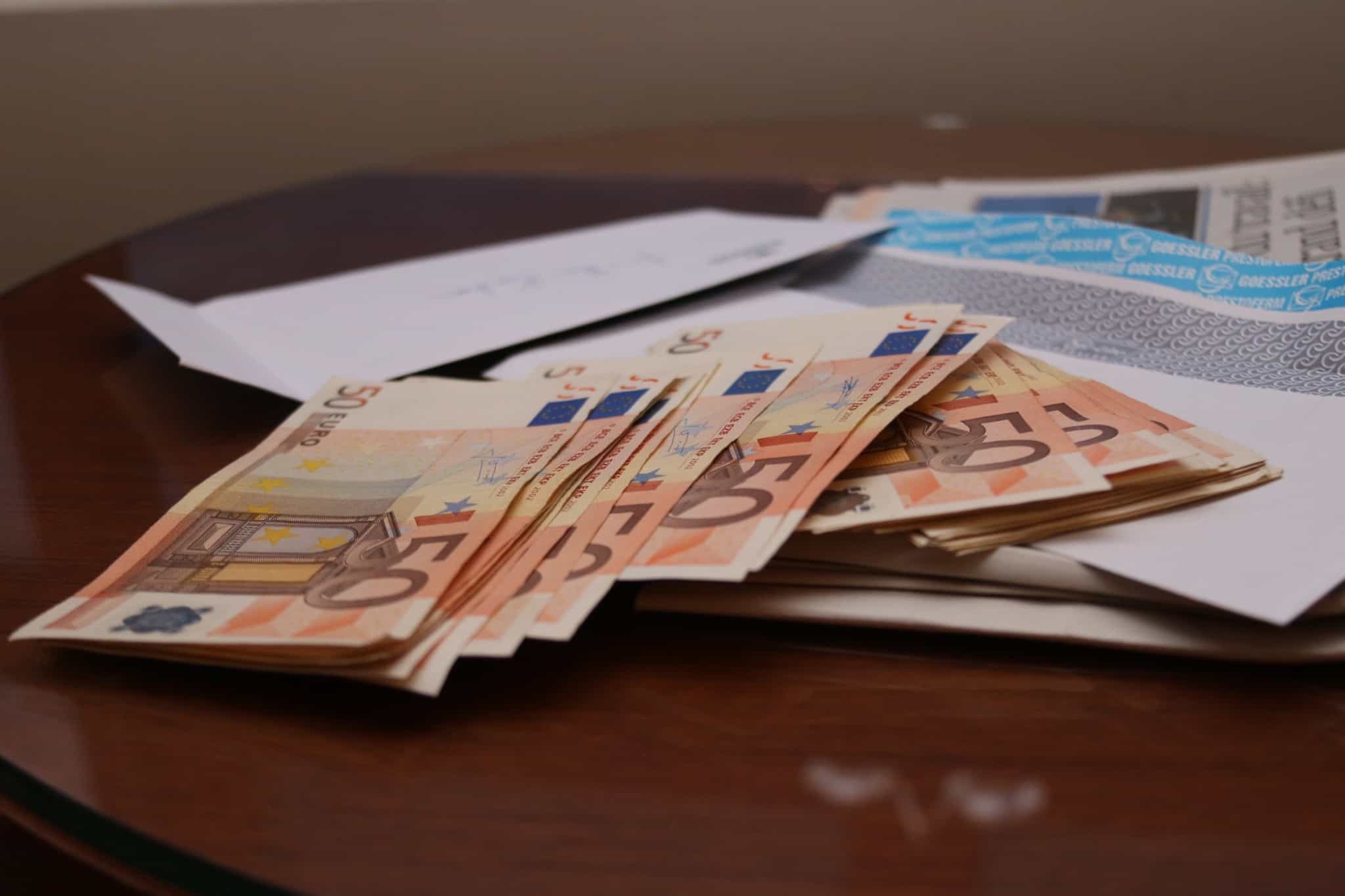 Um maço de notas de 50 euros em cima de uma mesa de madeira