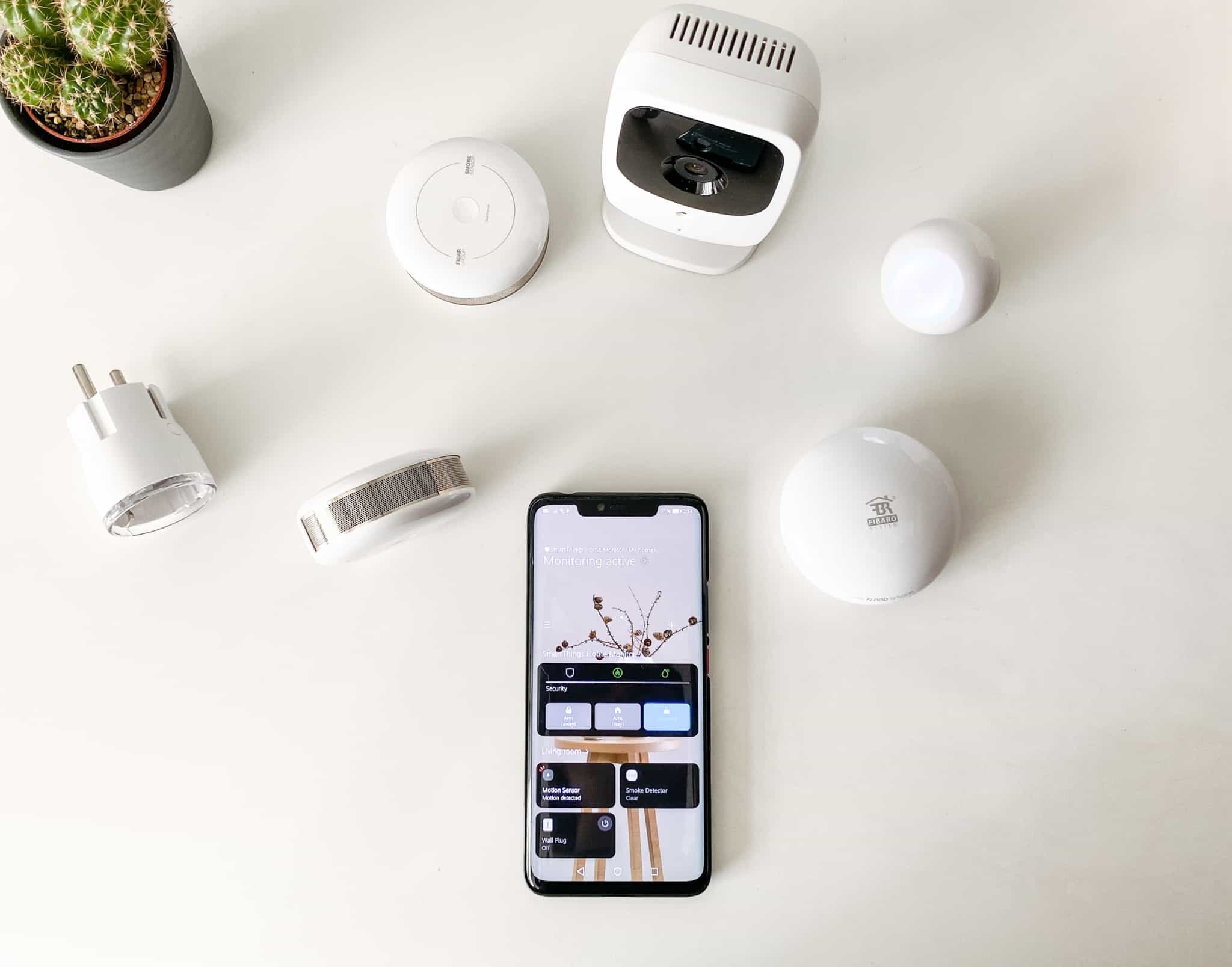 vário equipamentos e sensores de uma casa inteligente colocados juntos de um telemóvel