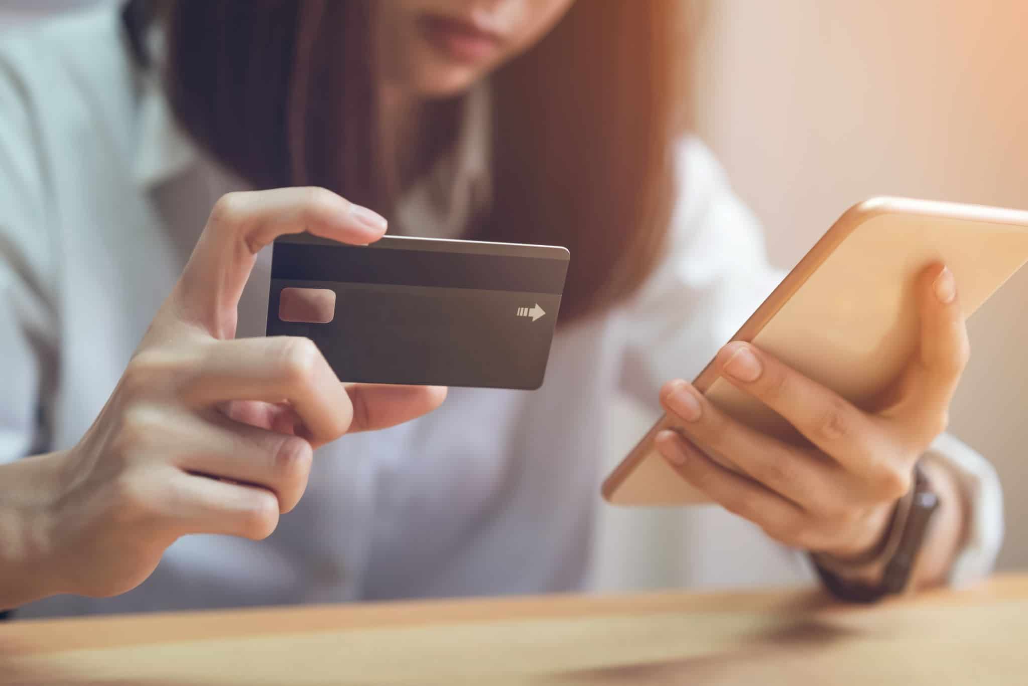 mulher a utilizar um cartão de crédito e um smartphone