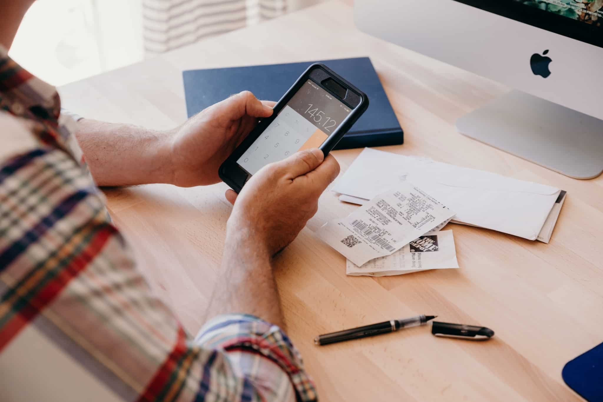 homem a fazer contas no telemóvel