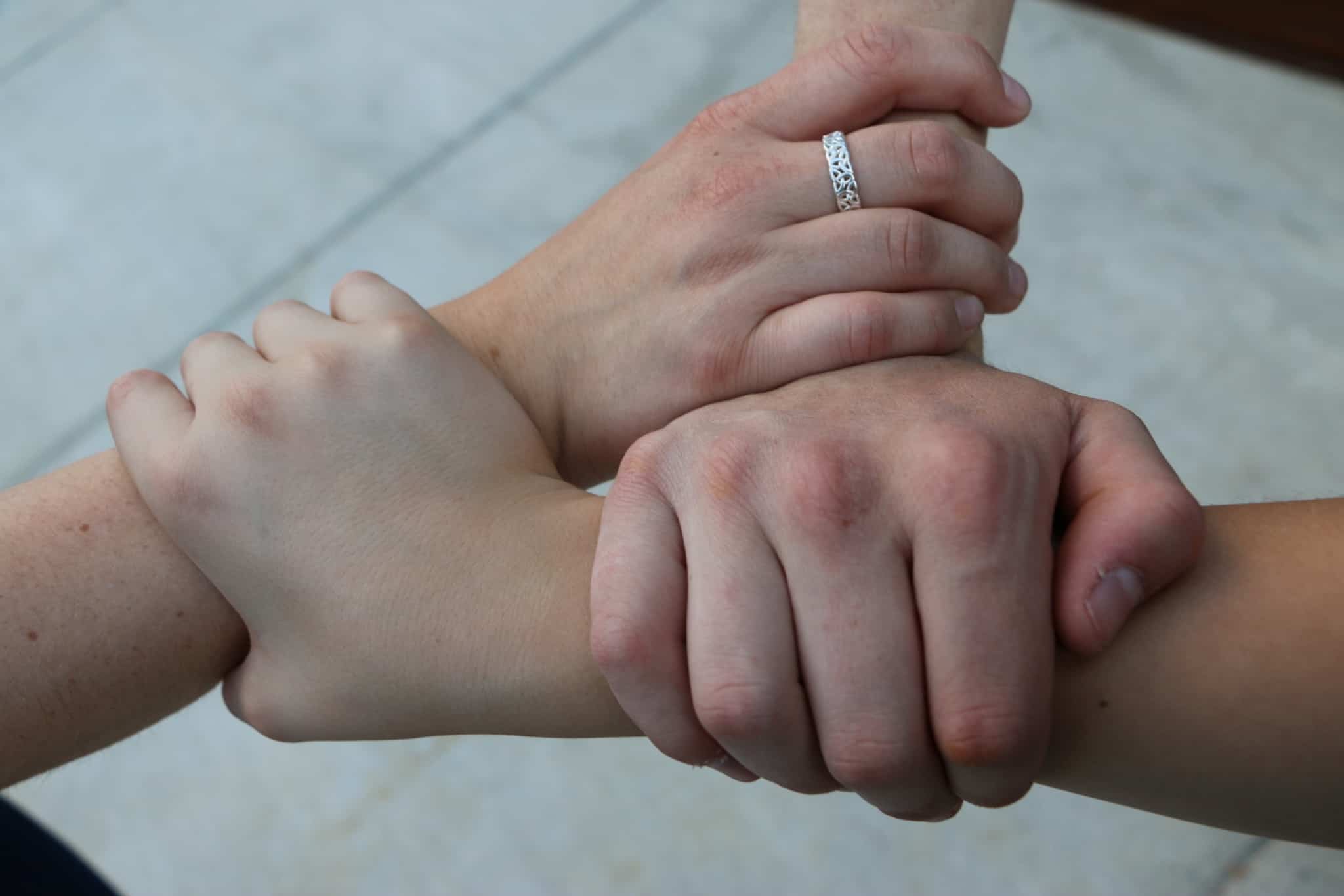 Três mãos entrelaçadas, num sinal de solidariedade