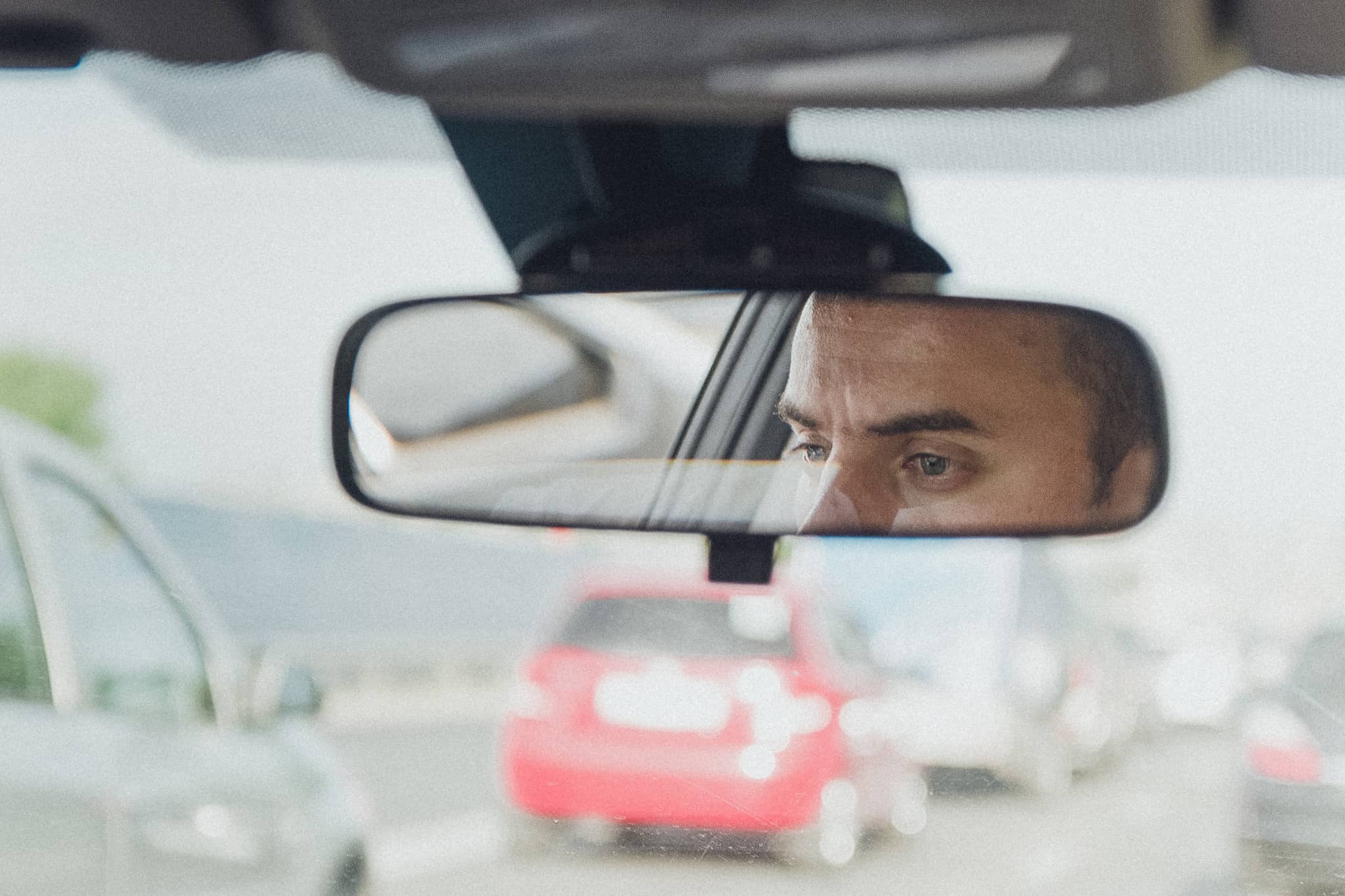Reflexo da cara de um condutor de carro no espelho refletor