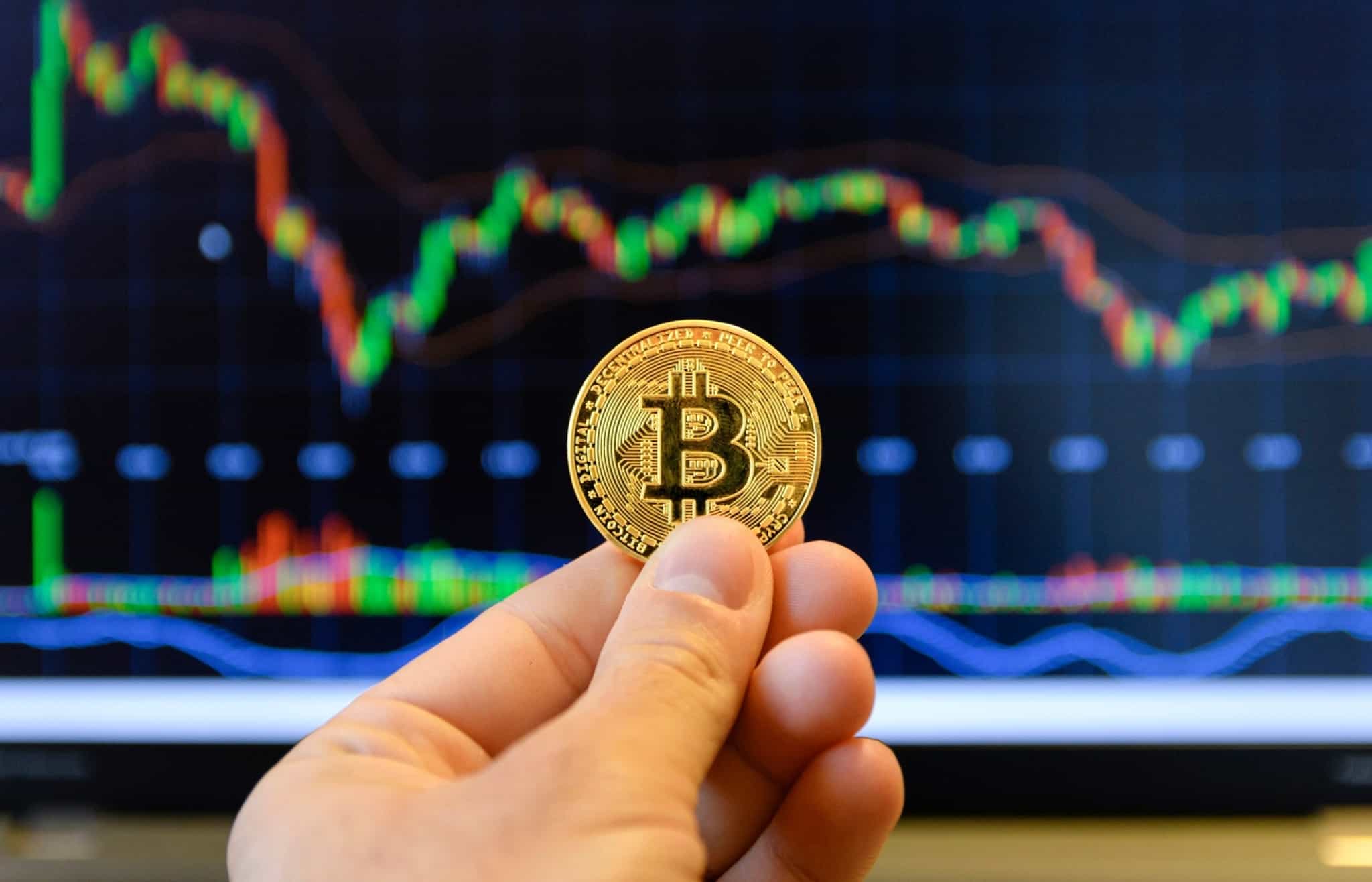 mão segura uma moeda de bitcoin